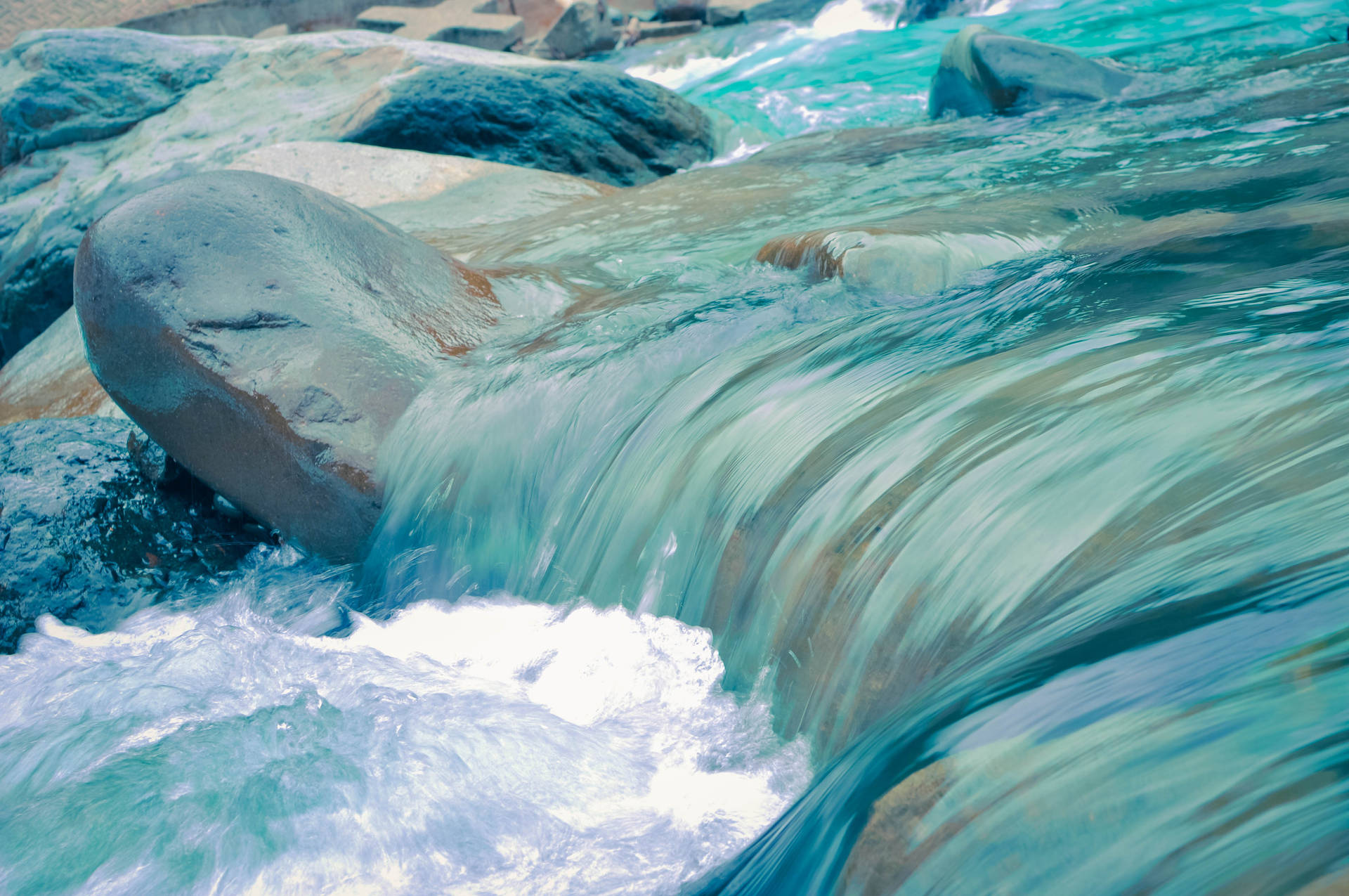 A Clean Blue River Cascading Through The Landscape Background