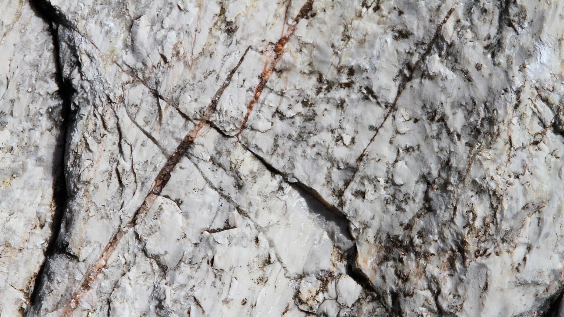 A Close Up Of A White Rock With A Black Streak
