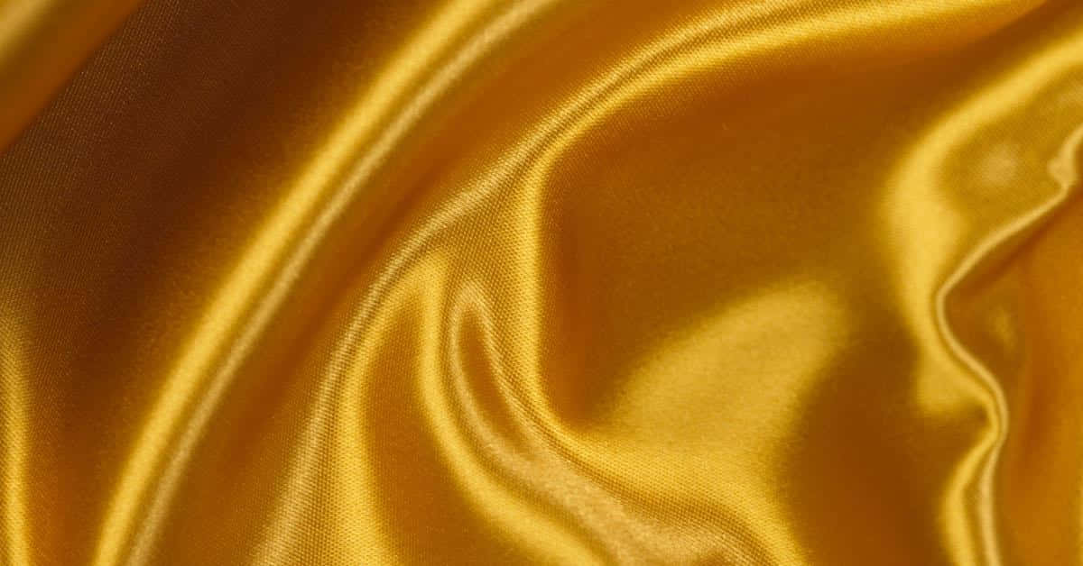 A Close Up Of A Yellow Satin Fabric Background