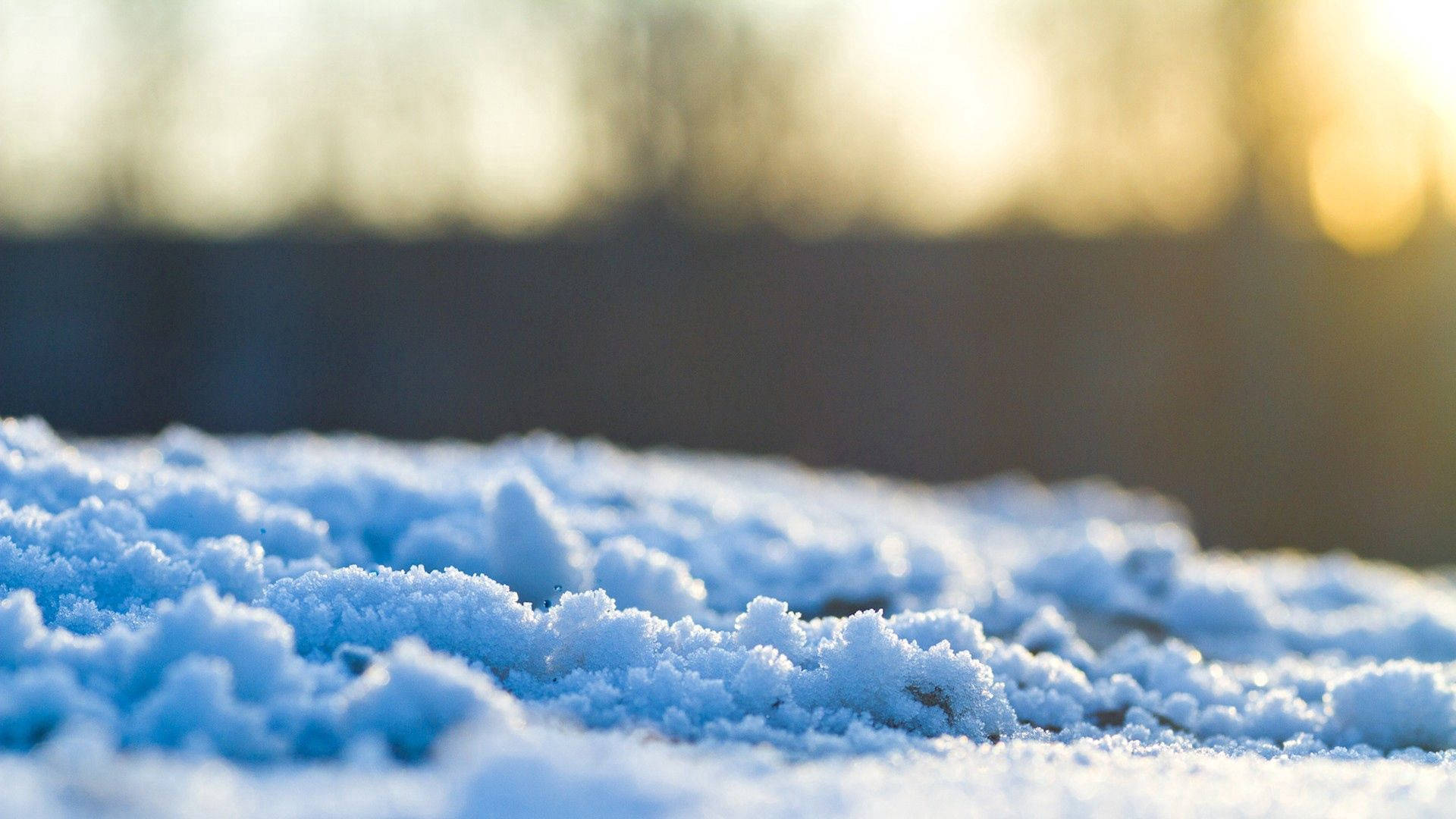 A Close Up Of Snow Covered Ground With The Sun Shining On It Background