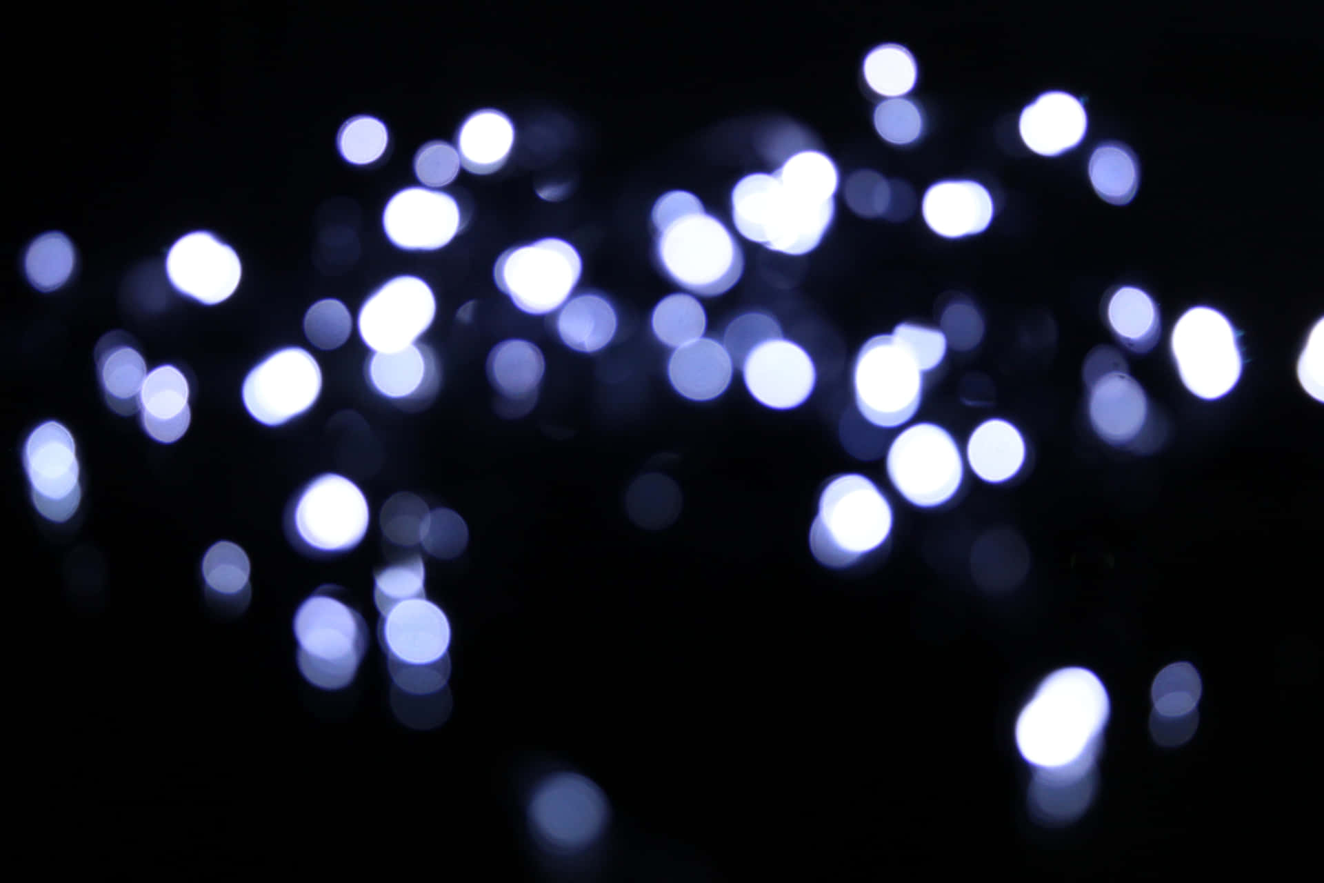 A Close Up Of White Lights On A Dark Background Background