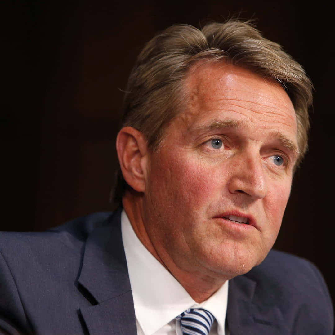 A Close-up Shot Of Jeff Flake Engaging In Conversation Background