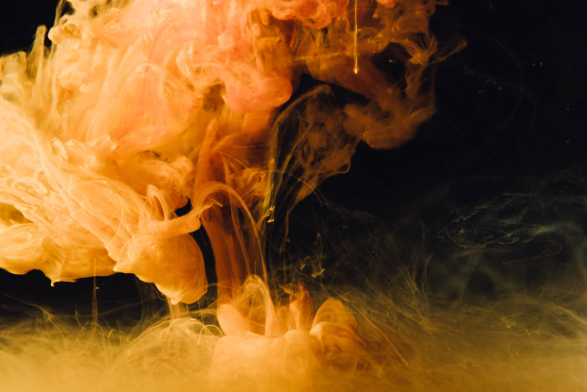 A Cloud Of Orange Smoke Against A Black Background Background