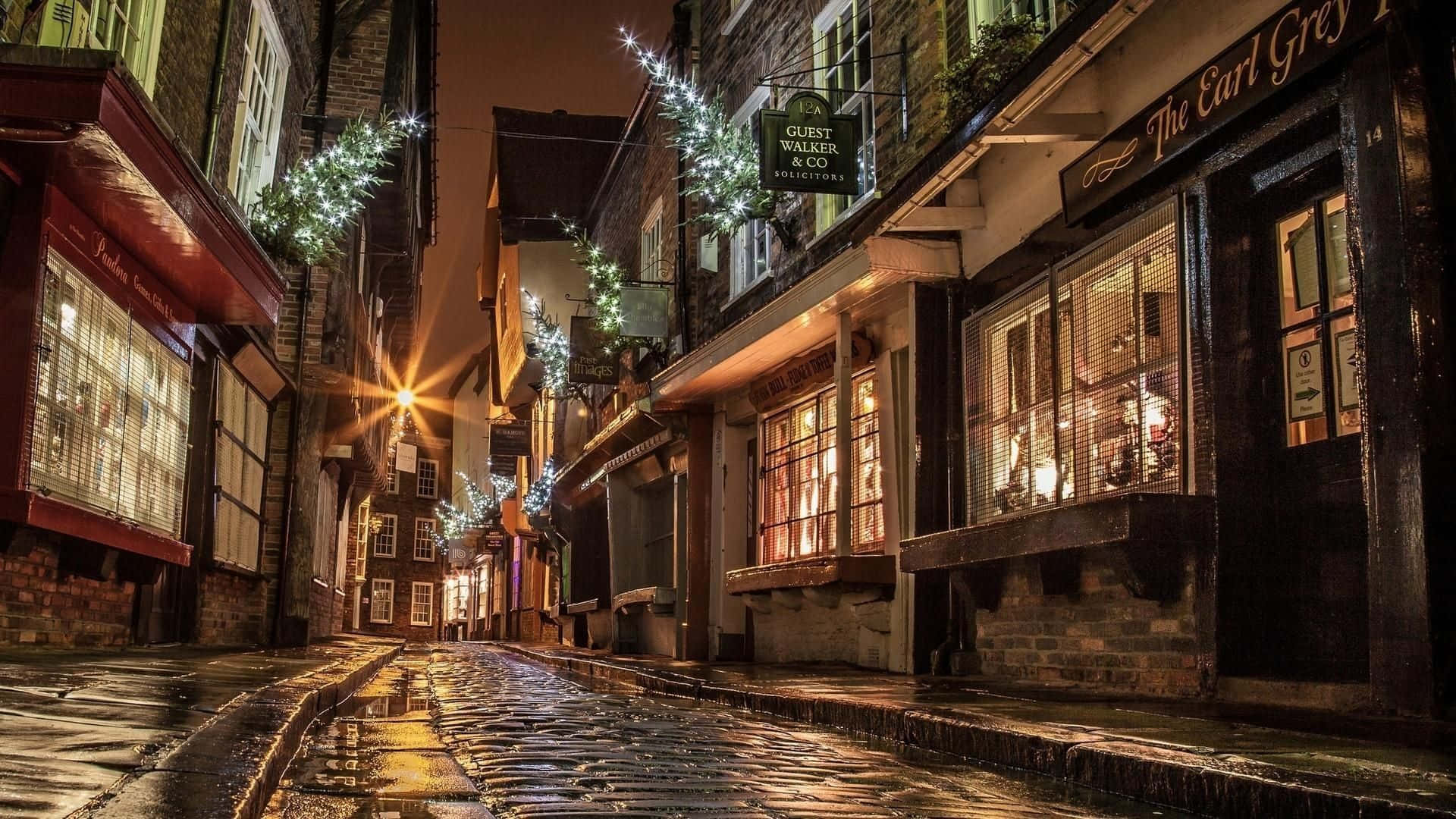 A Cobbled Street With Lights And Decorations