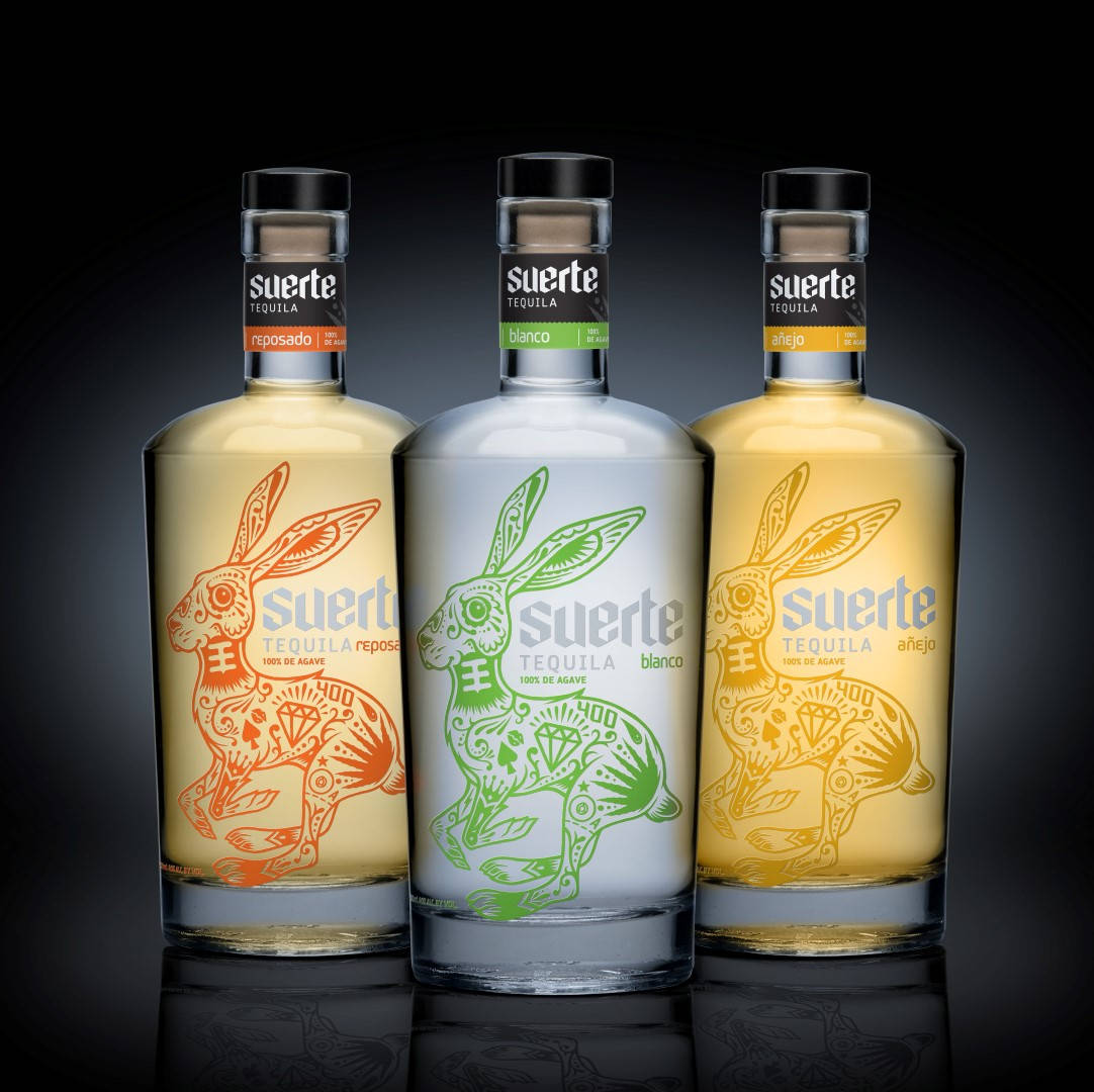 A Collection Of Suerte Tequila Bottles Background