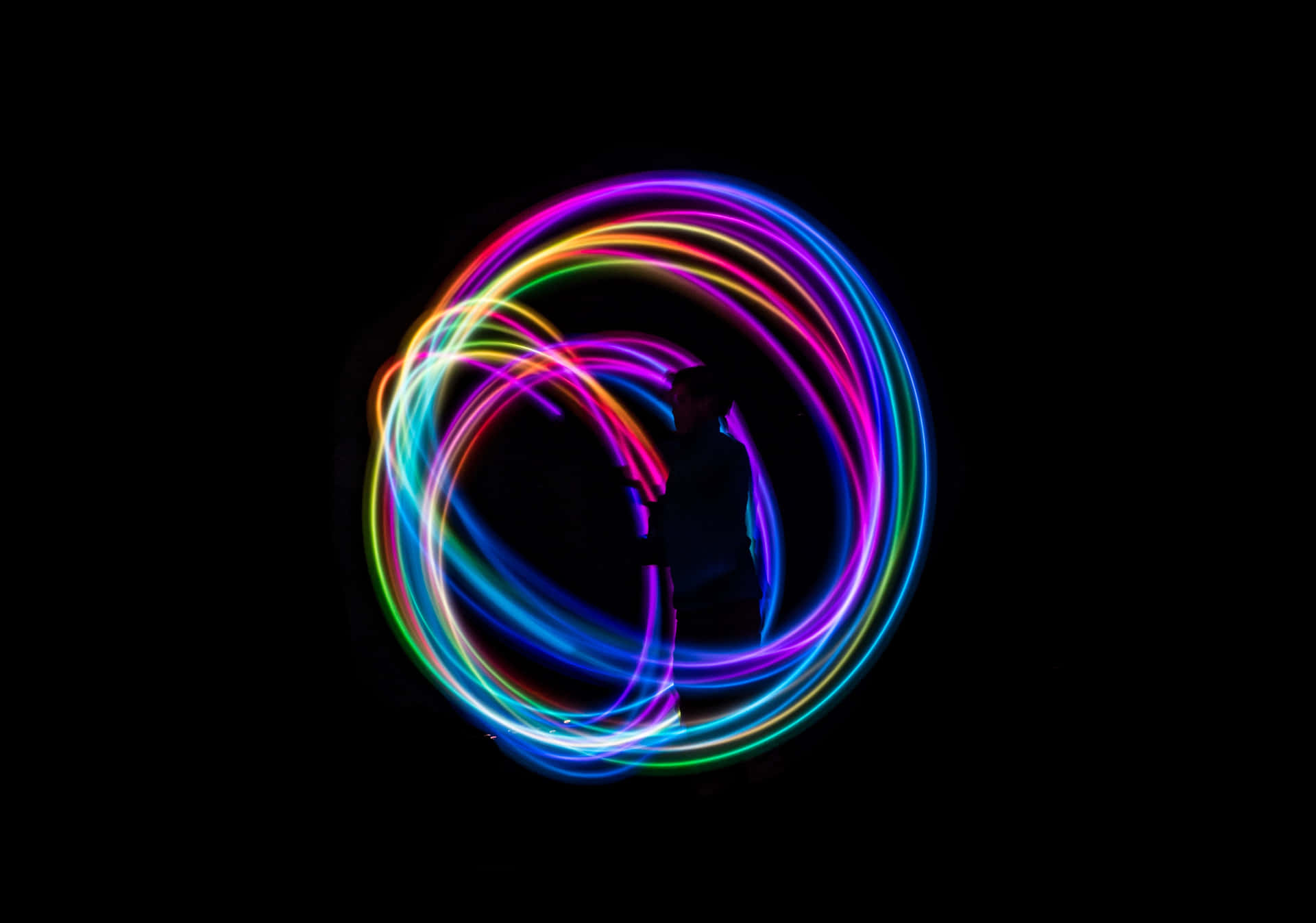 A Colorful Light Ring On A Black Background Background