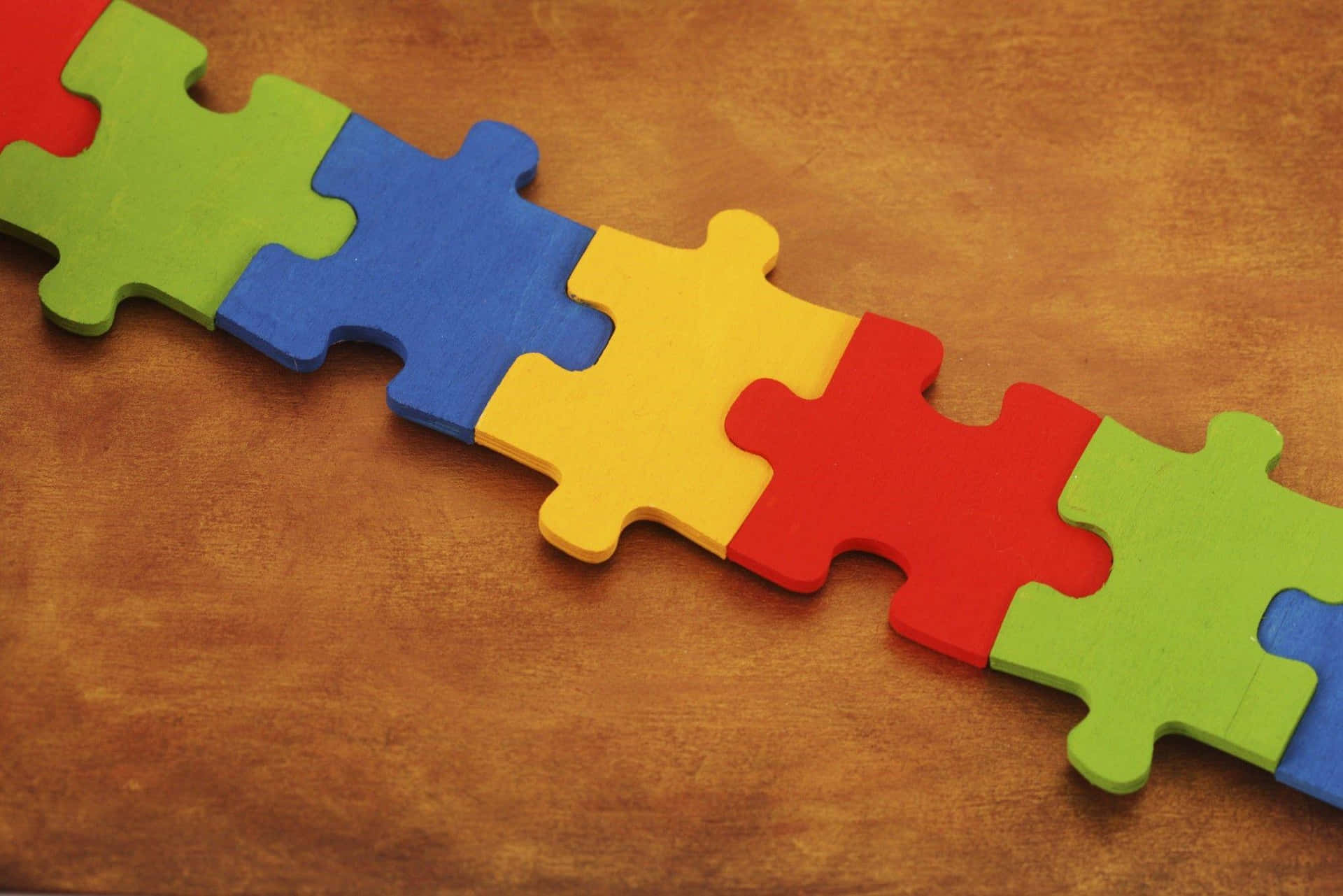 A Colorful Puzzle Piece On A Brown Background Background