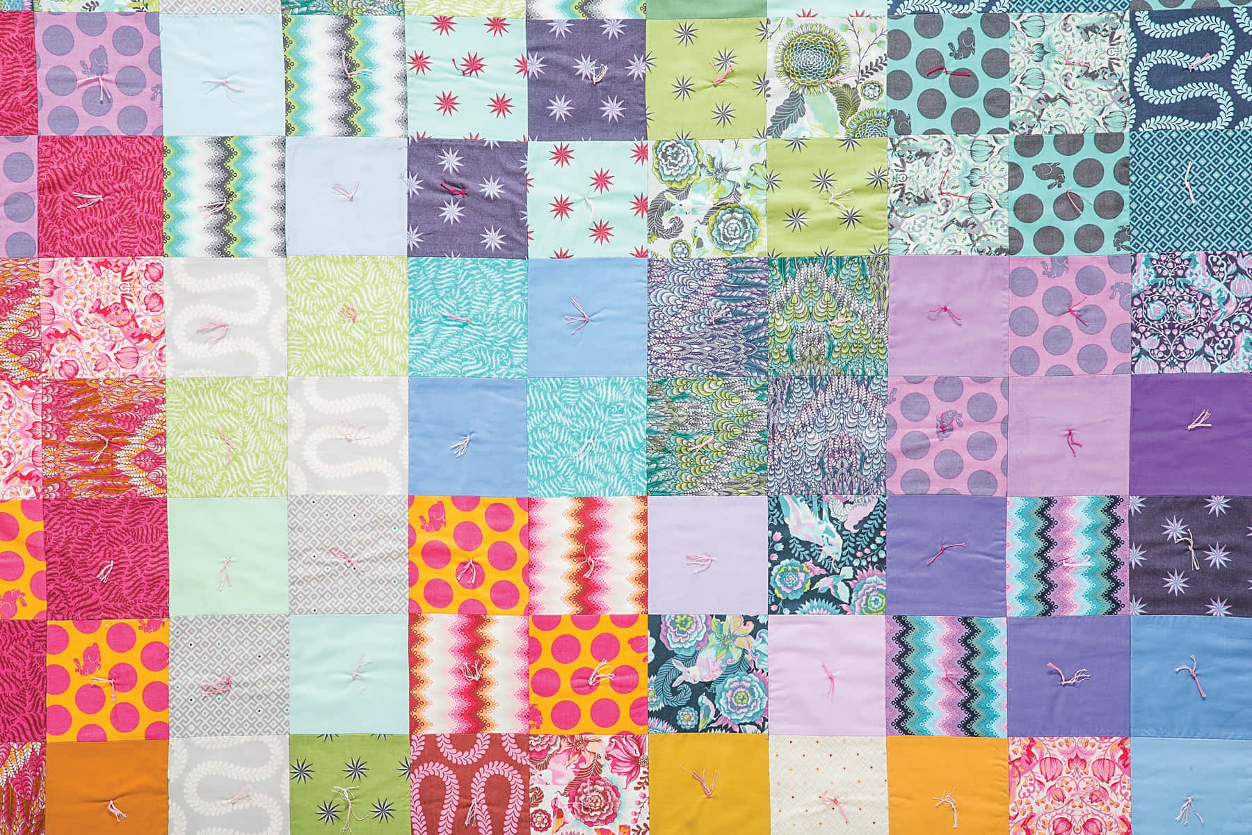 A Colorful Quilt With Many Different Colors Background