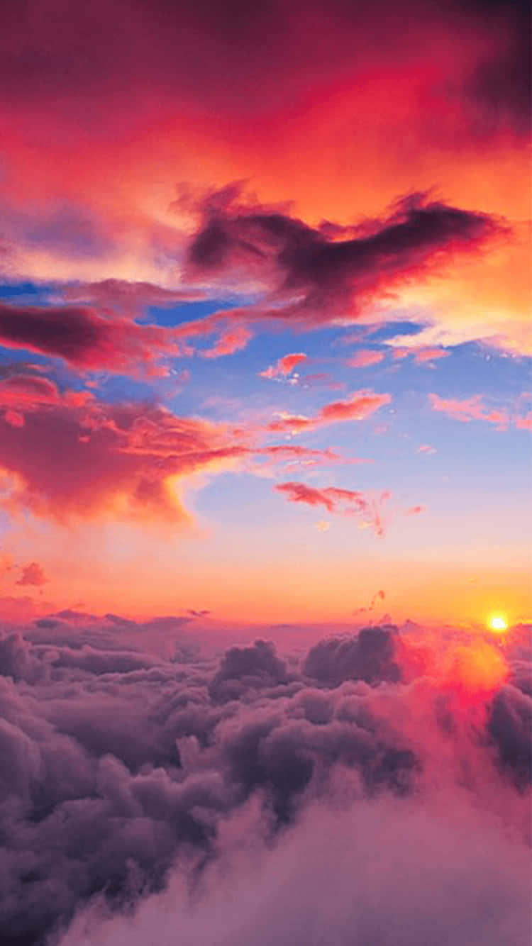 A Colorful Sunset Over The Clouds Background