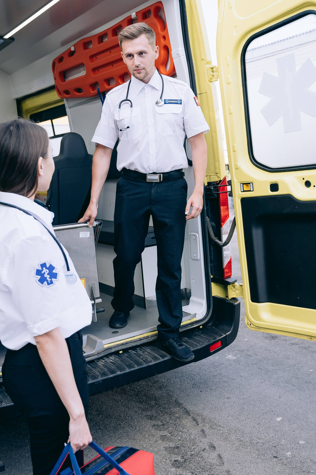 A Committed Paramedic Standing Inside An Ambulance. Background