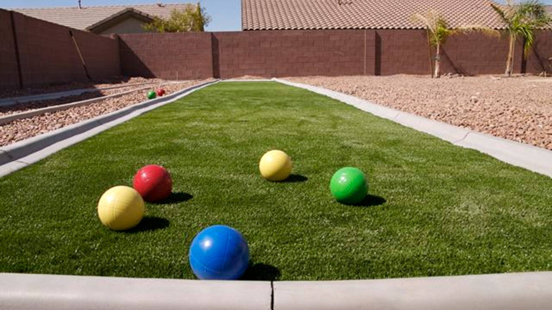 A Competitive Bocce Ball Game On A Vibrant Green Court Background