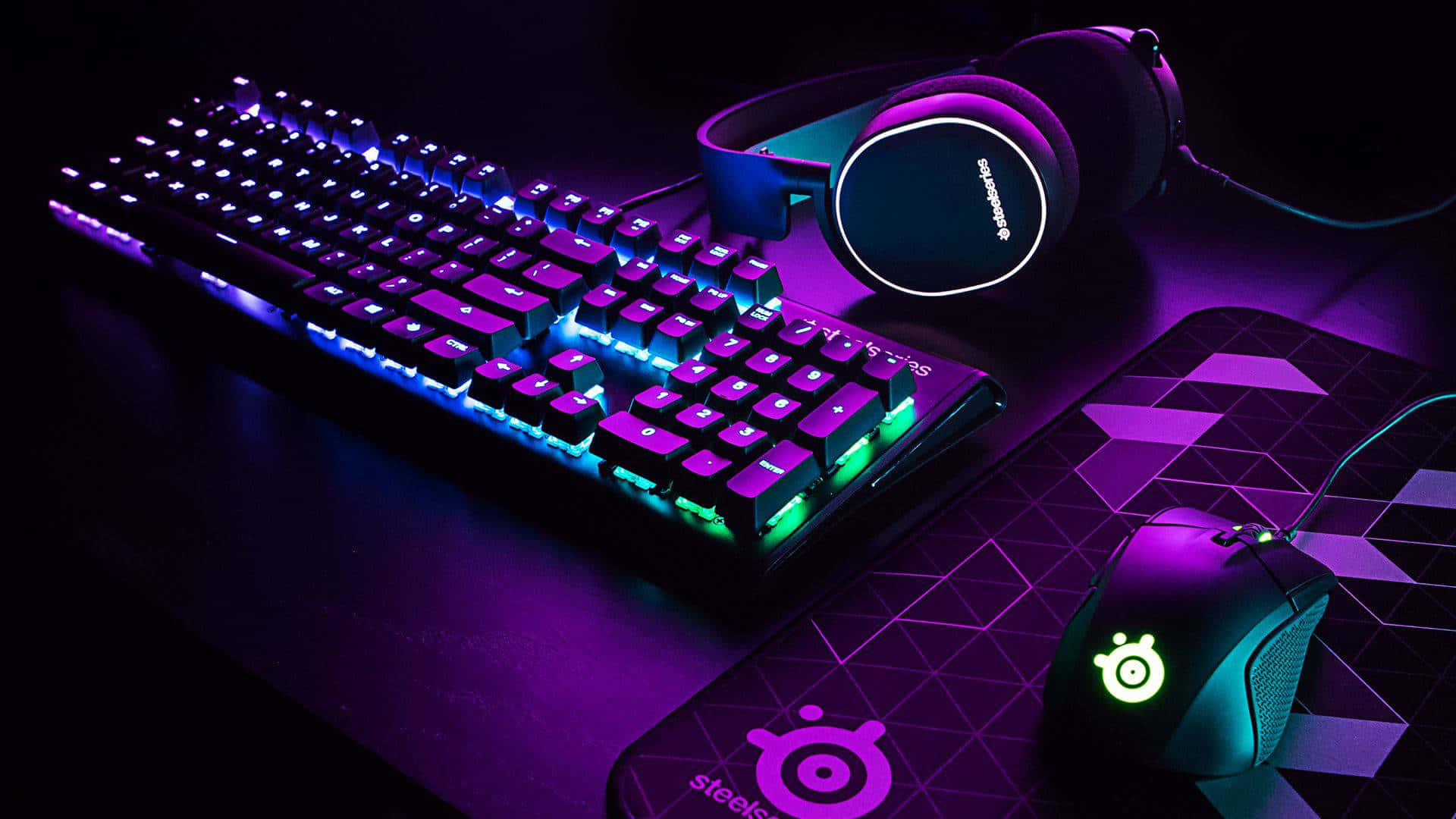 A Computer Keyboard And Mouse With Purple Lights Background