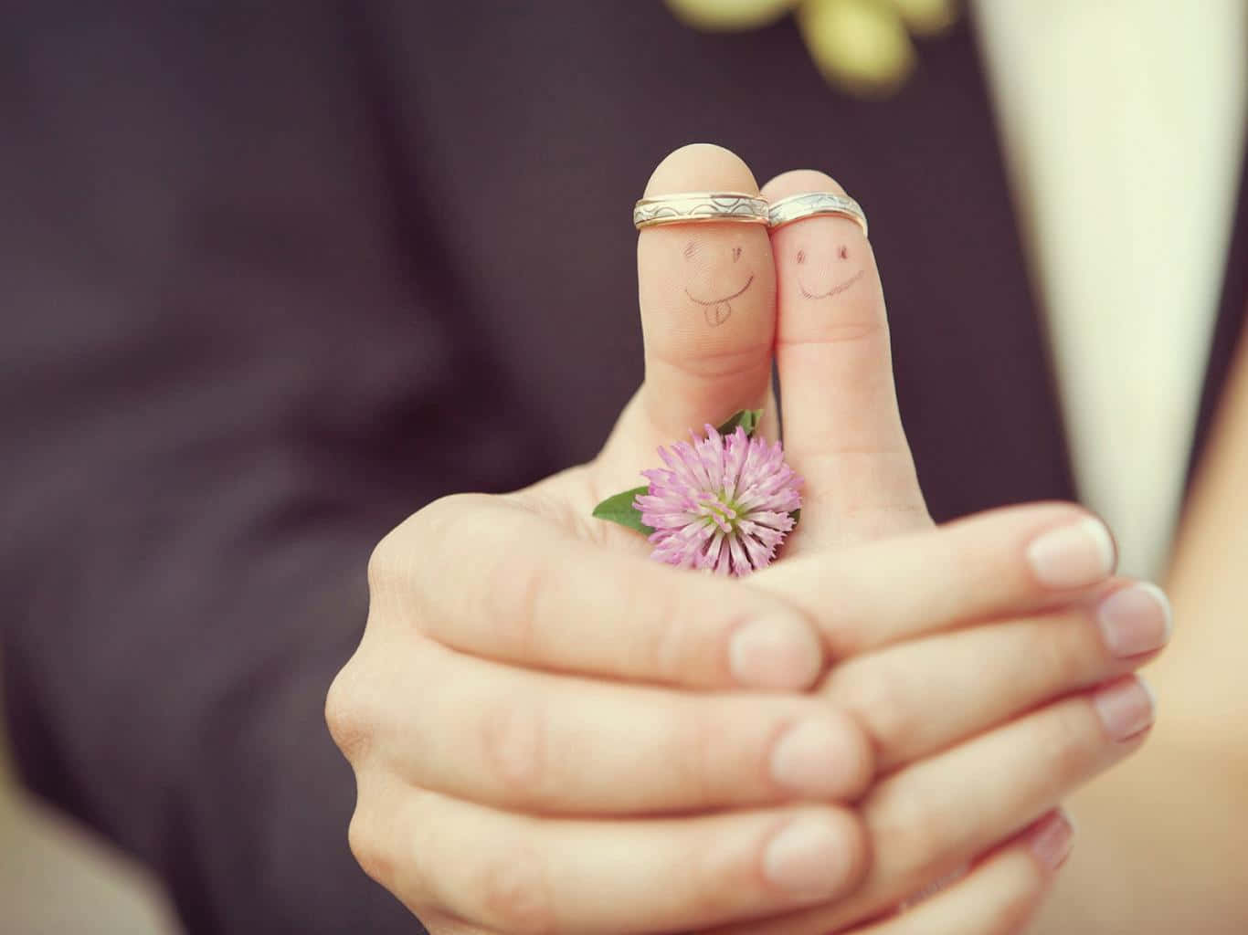 A Couple Holding Their Wedding Rings And Smiling Faces Background