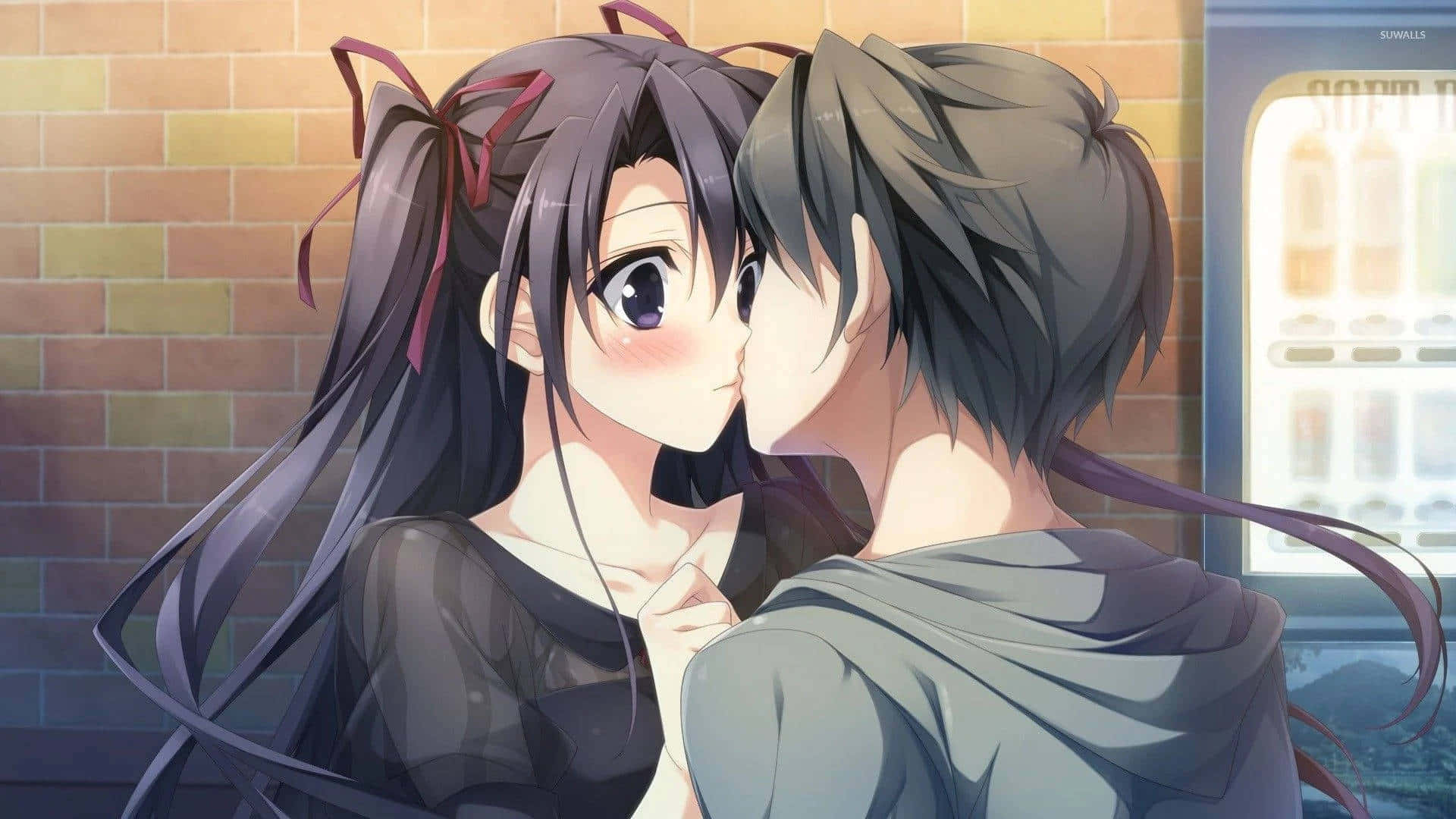 A Couple Kissing In Front Of A Brick Wall Background