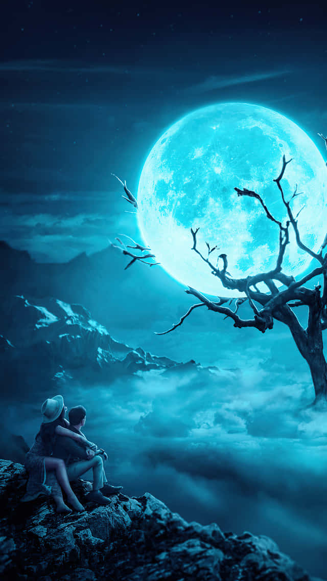 A Couple Sitting On A Rock Looking At The Moon Background