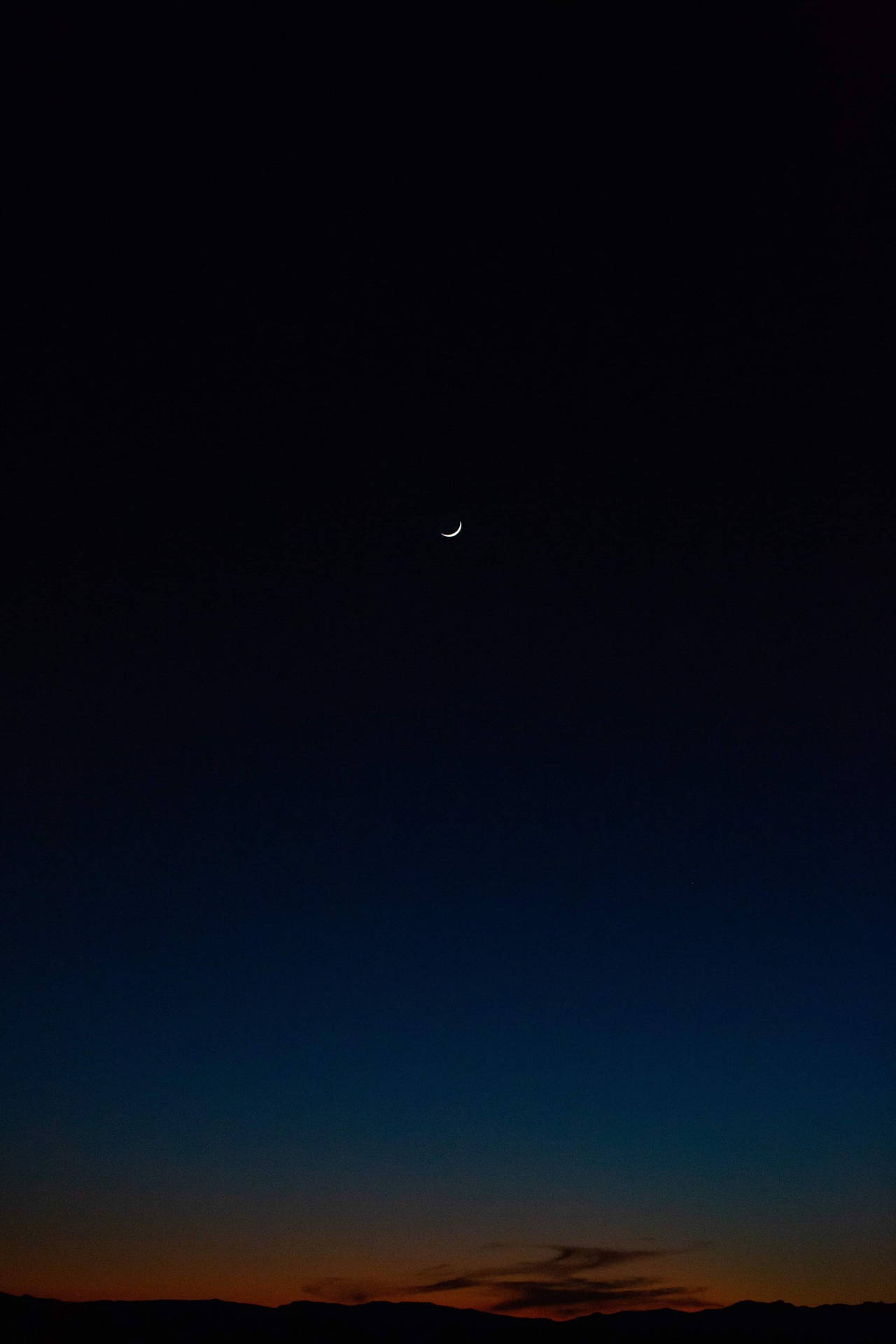 A Crescent Is Seen In The Sky Over A Desert Background