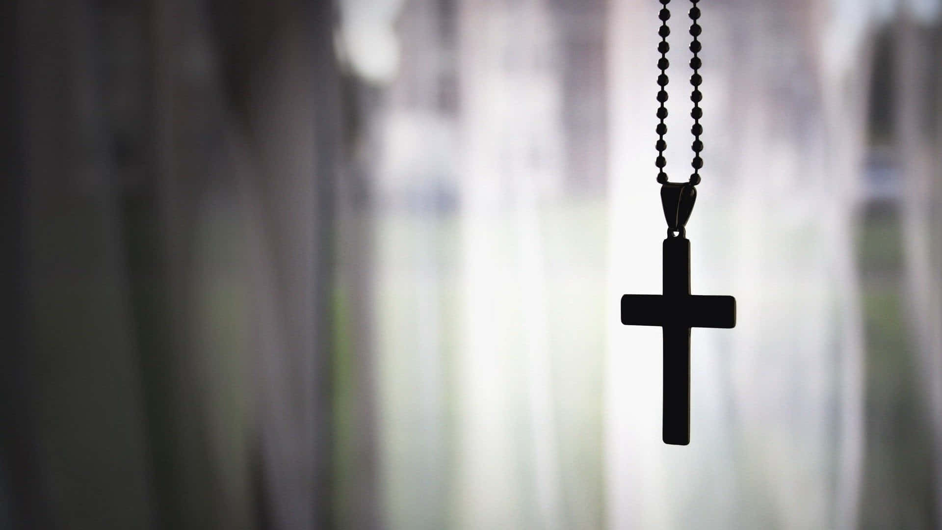 A Cross Hanging From A Curtain Background