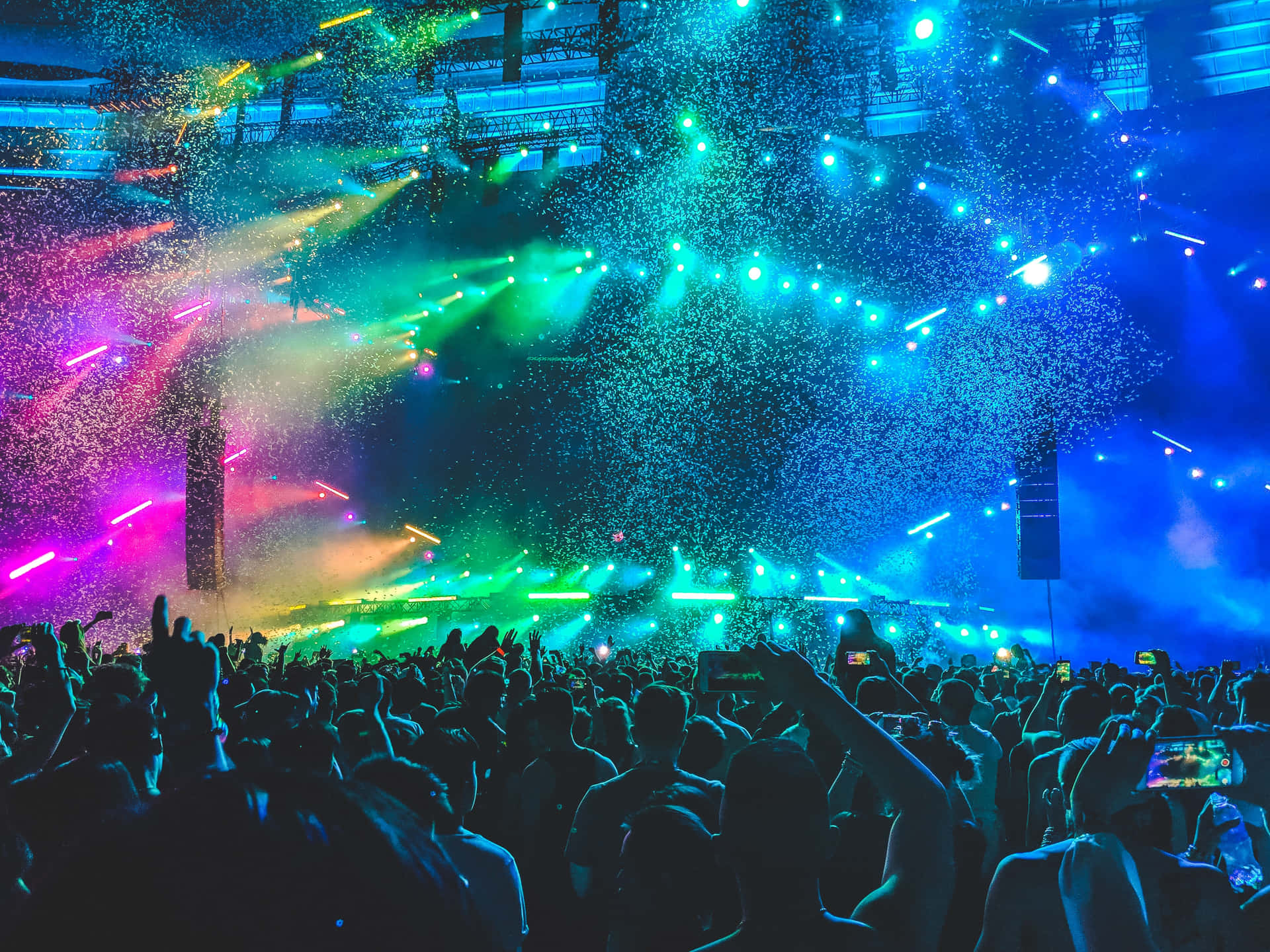 A Crowd At A Concert With Colorful Lights Background