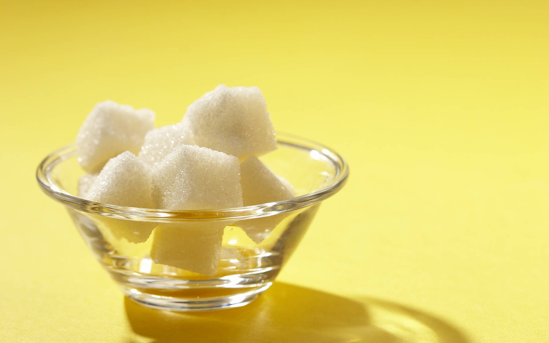 A Crystal Clear Bowl Filled With Sugar Cubes