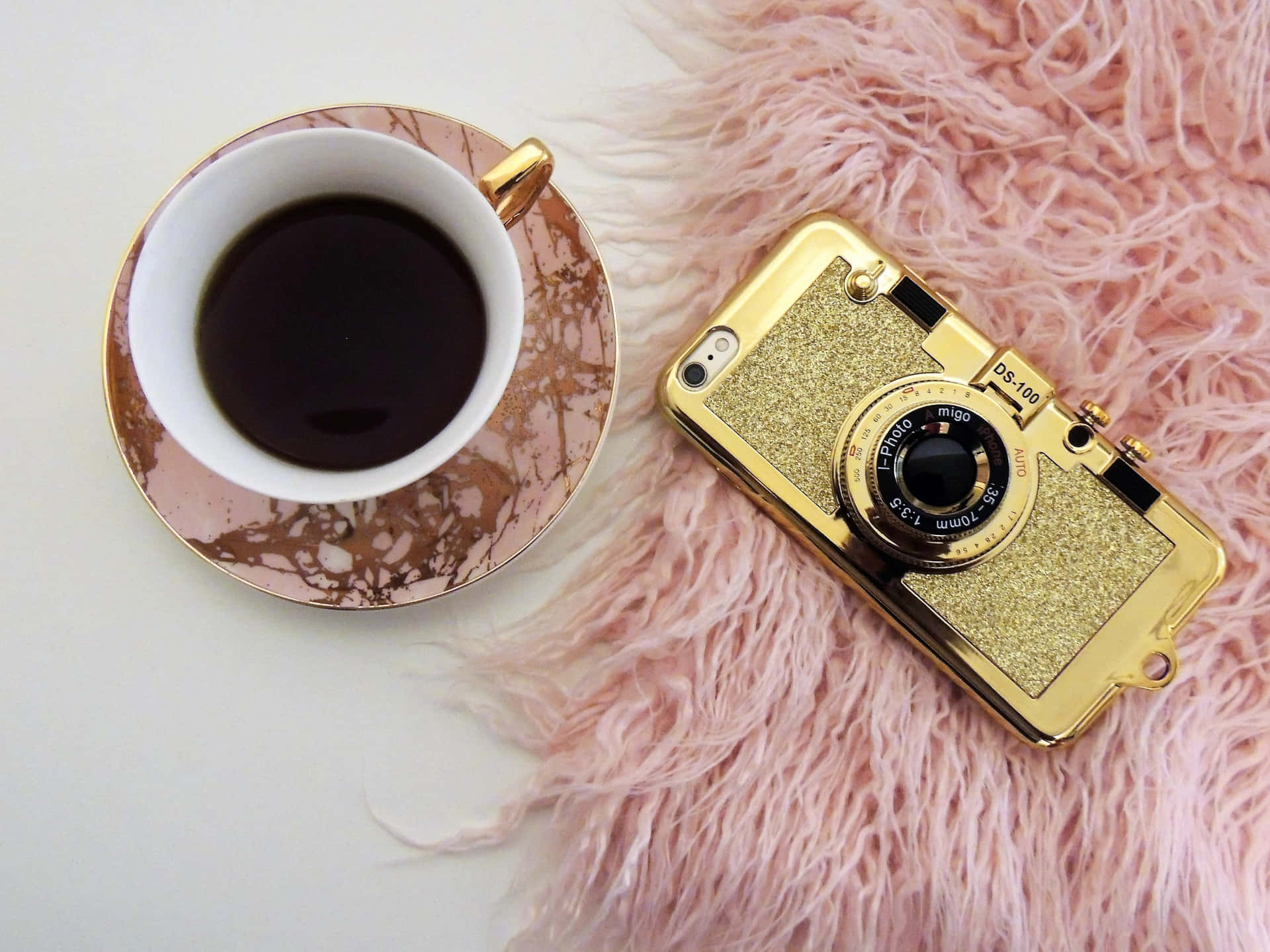 A Cup Of Coffee And A Gold Camera On A Pink Fur