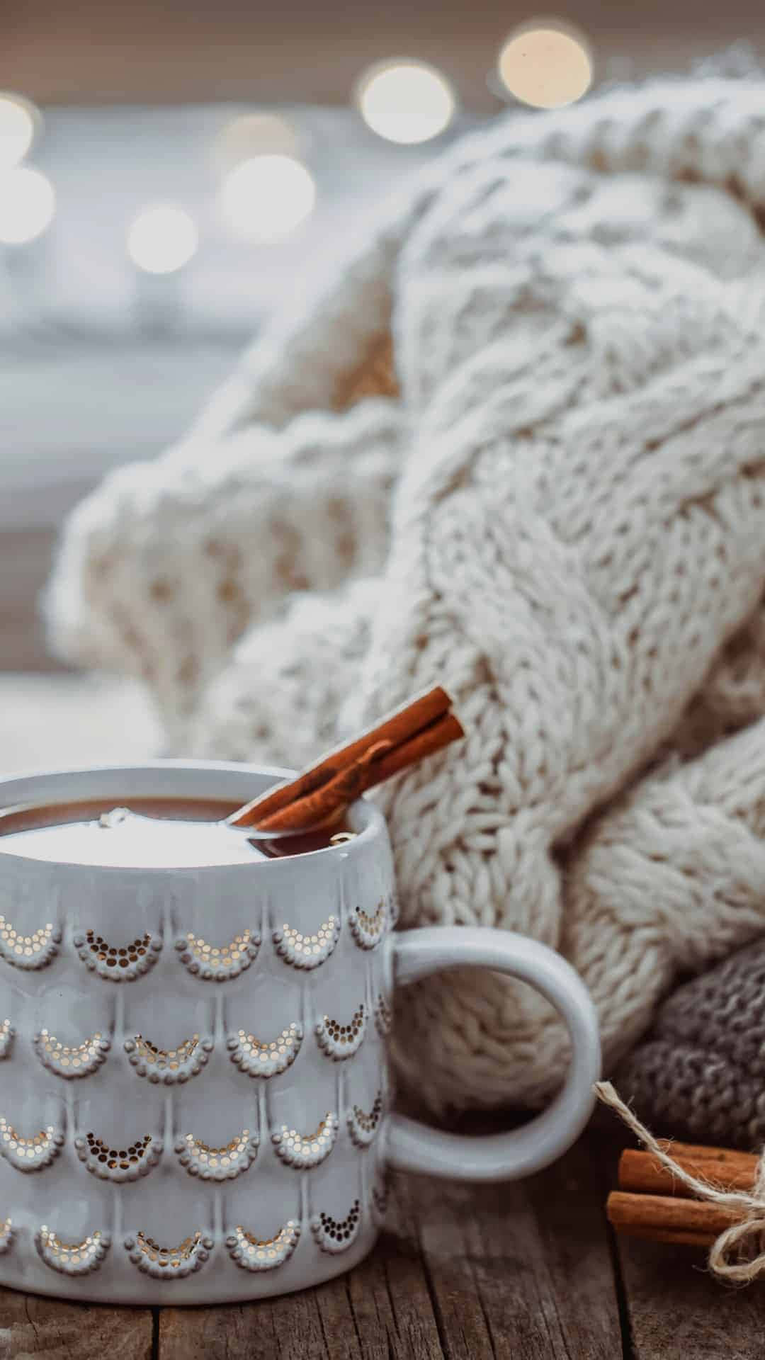 A Cup Of Hot Chocolate With Cinnamon Sticks And A Knitted Sweater Background