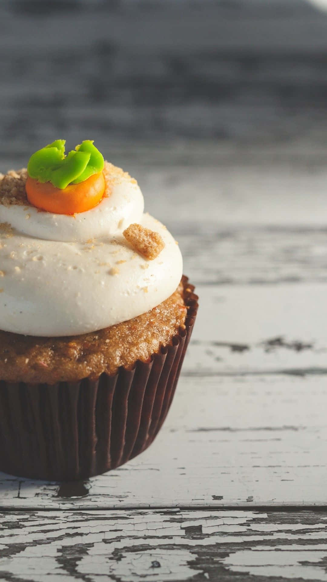 A Cupcake With Carrots On Top Background