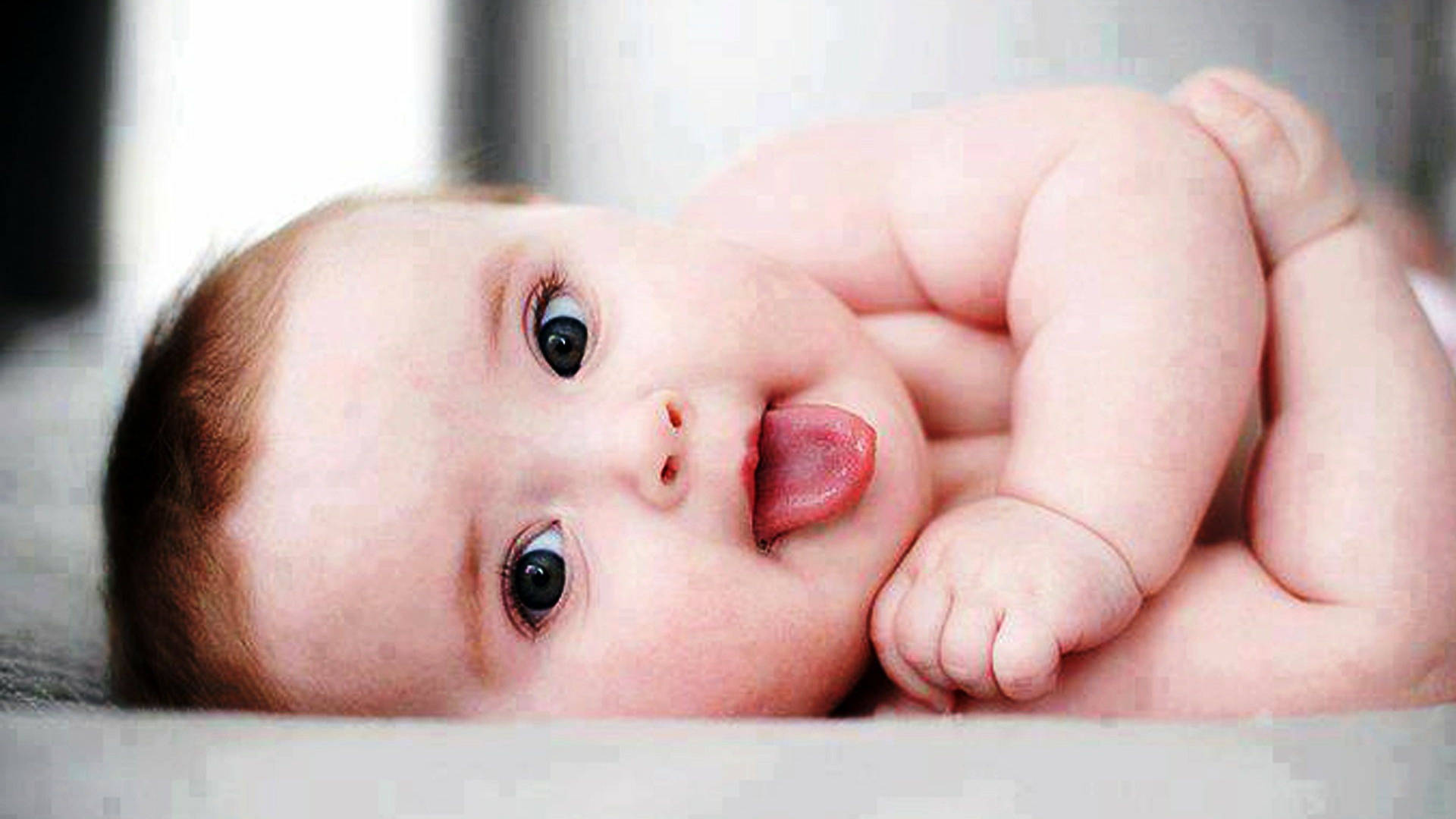 A Cute Baby, Ready For Fun With His Tongue Out Background