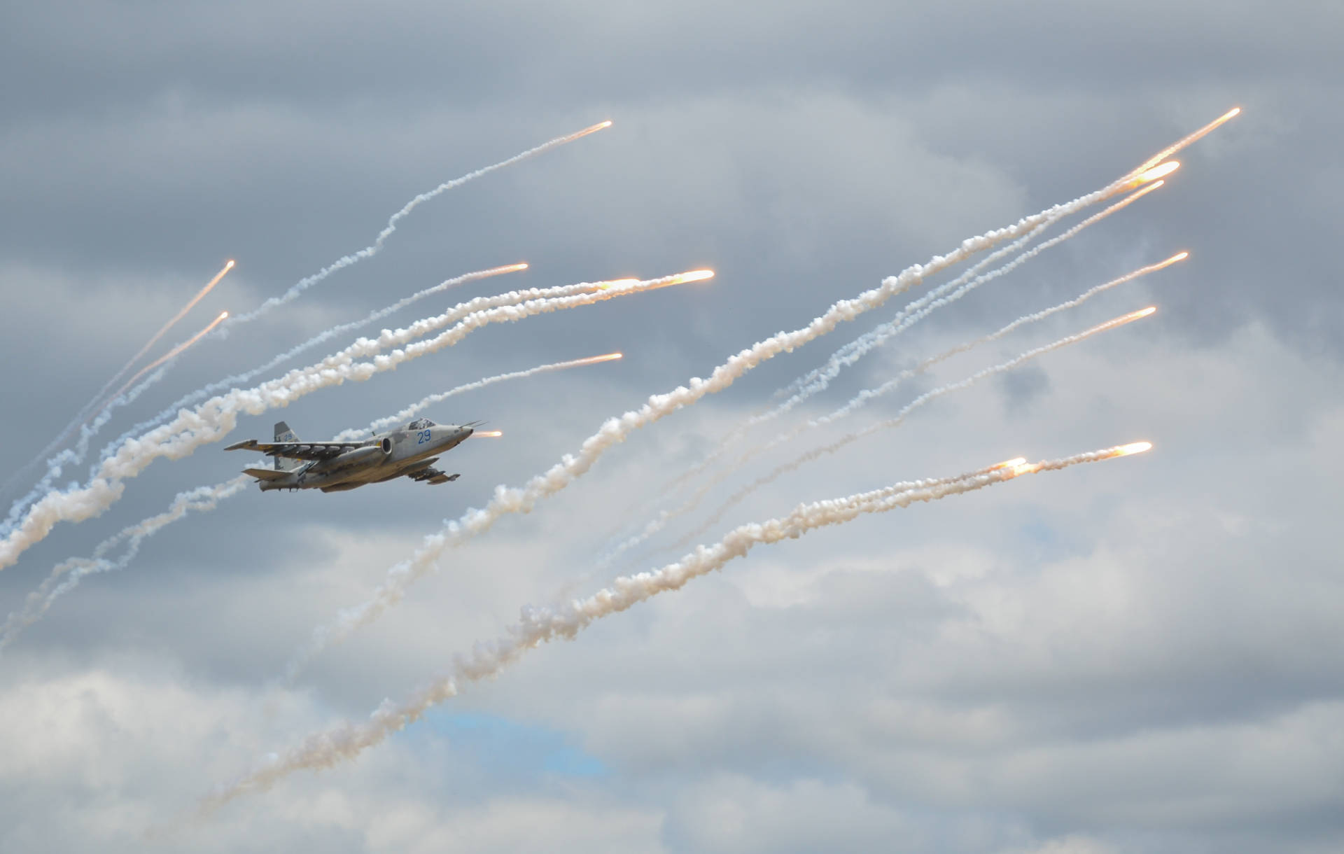 A Daring Fighter Plane Soaring Through A Blue Sky Background