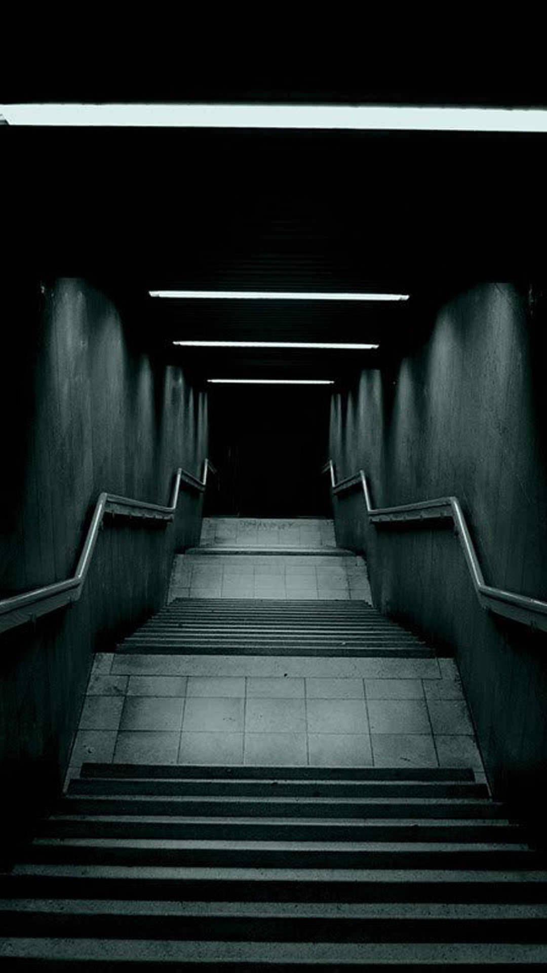 A Dark Hallway With Stairs Leading Down To A Dark Room Background