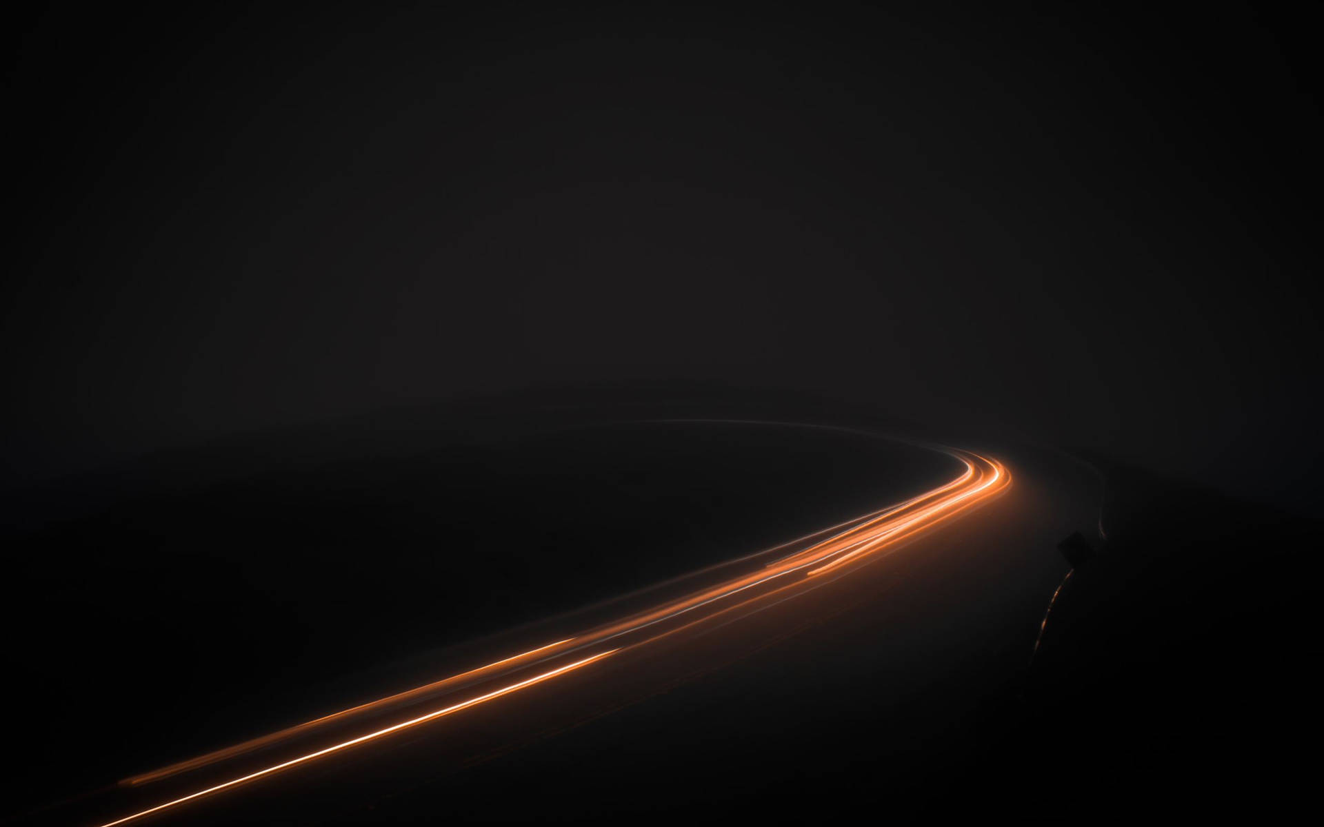 A Dark Road With Light Trails In The Dark Background
