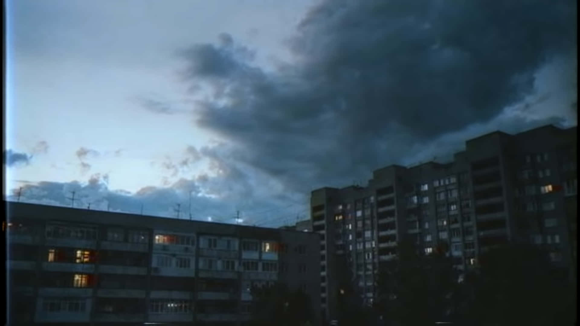 A Dark Sky Over A City With Buildings Background