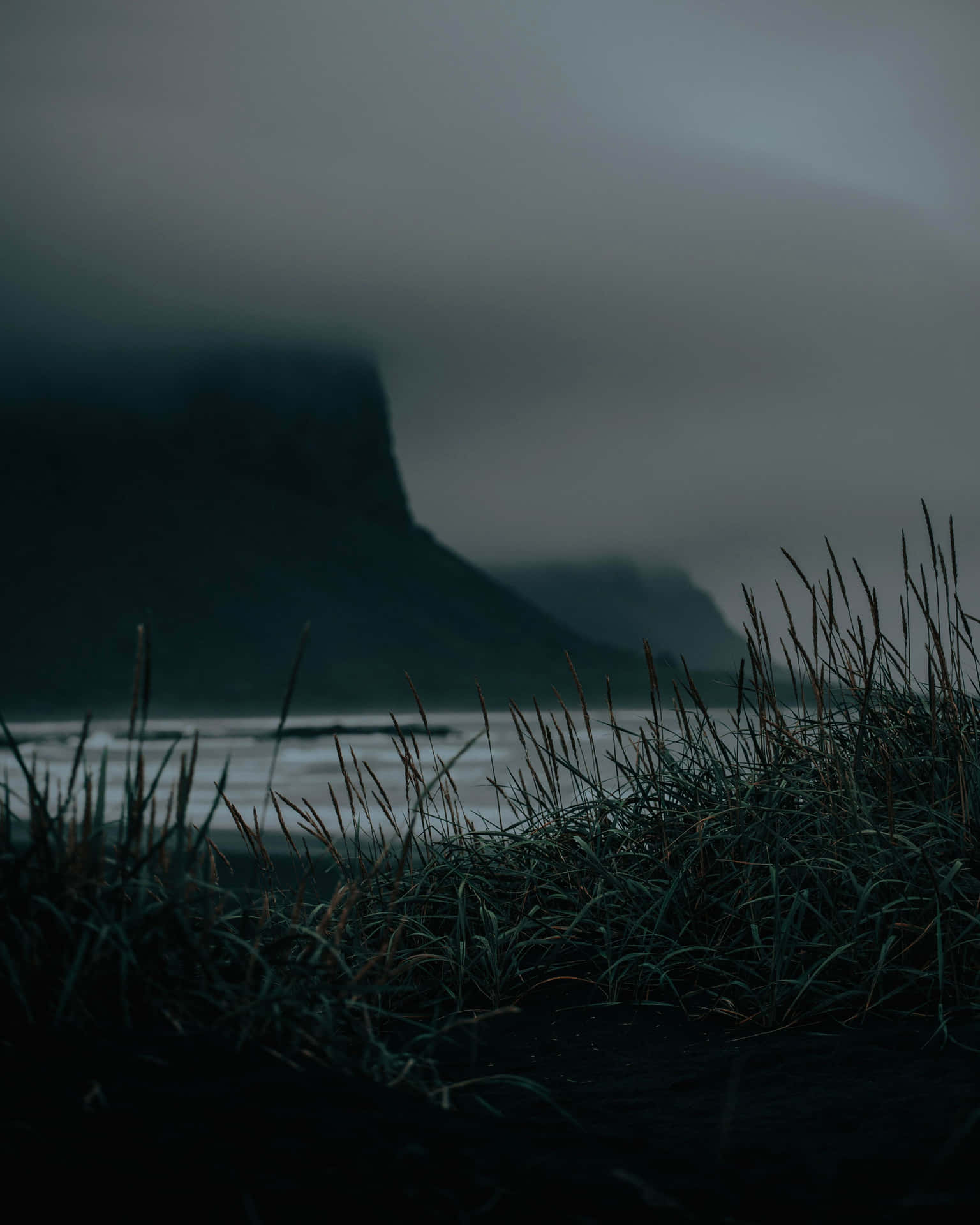 A Dark Sky With A Mountain In The Background