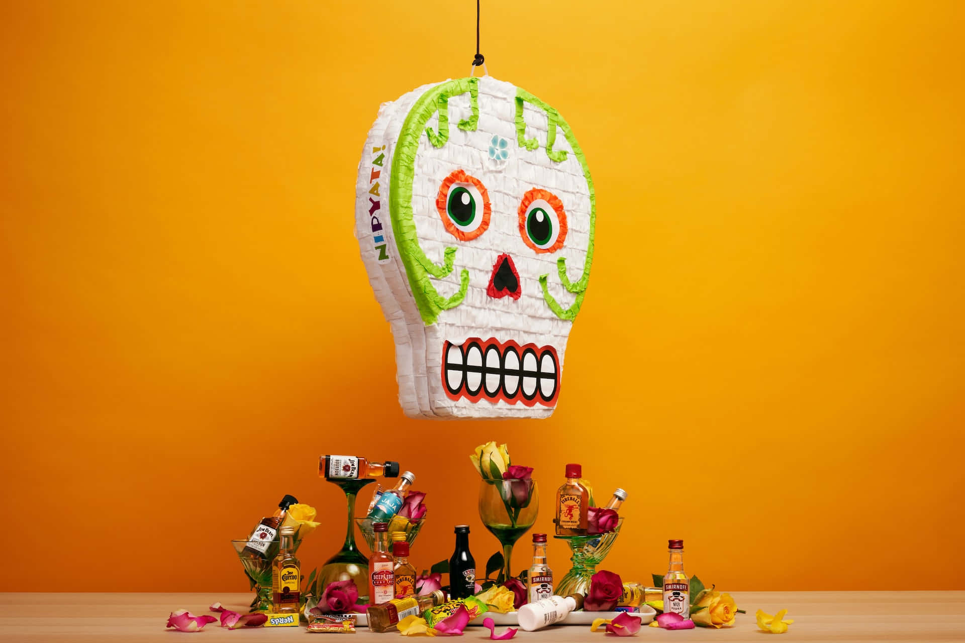 A Day Of The Dead Skull Hanging From A String Of Colorful Pinatas Background