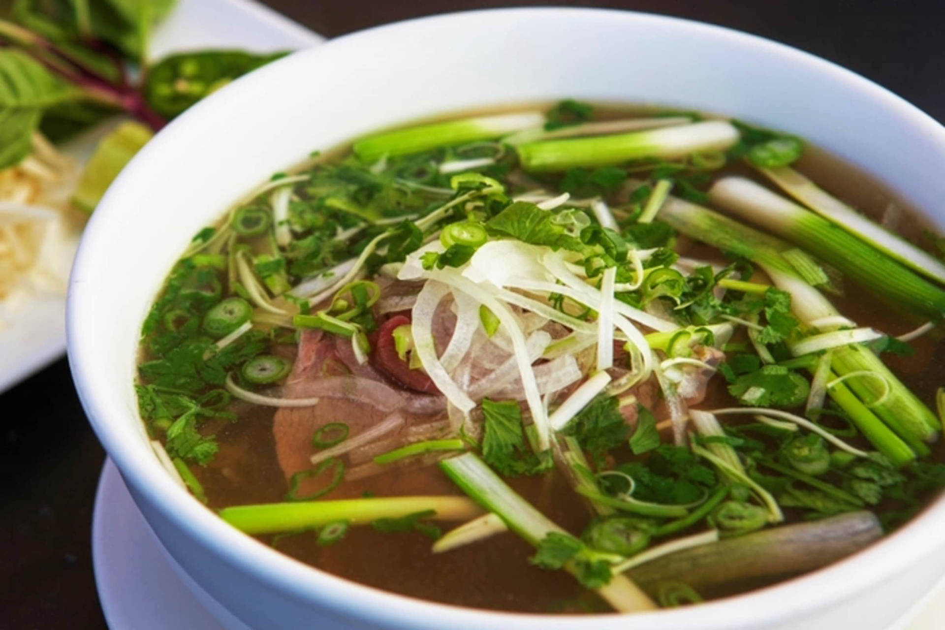 A Delicious Bowl Of Beef Pho With Spring Onions Background