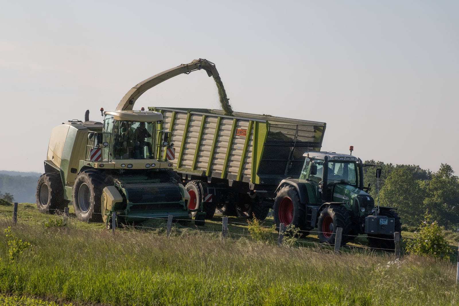 A Diligent Farmer Operating A Thresher On A Tractor In The Field.