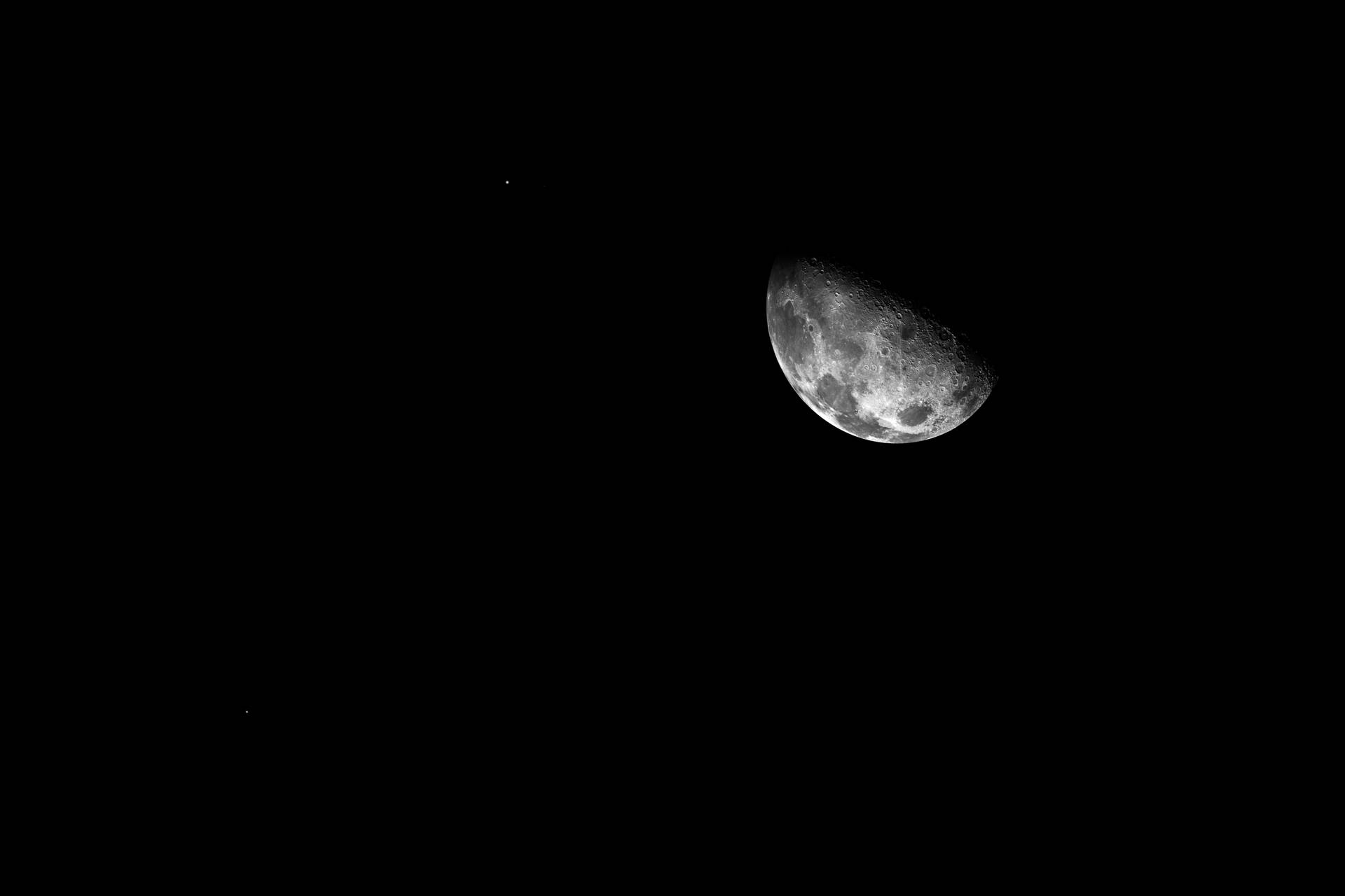 A Dimly Lit Moon And Dark Sky Background