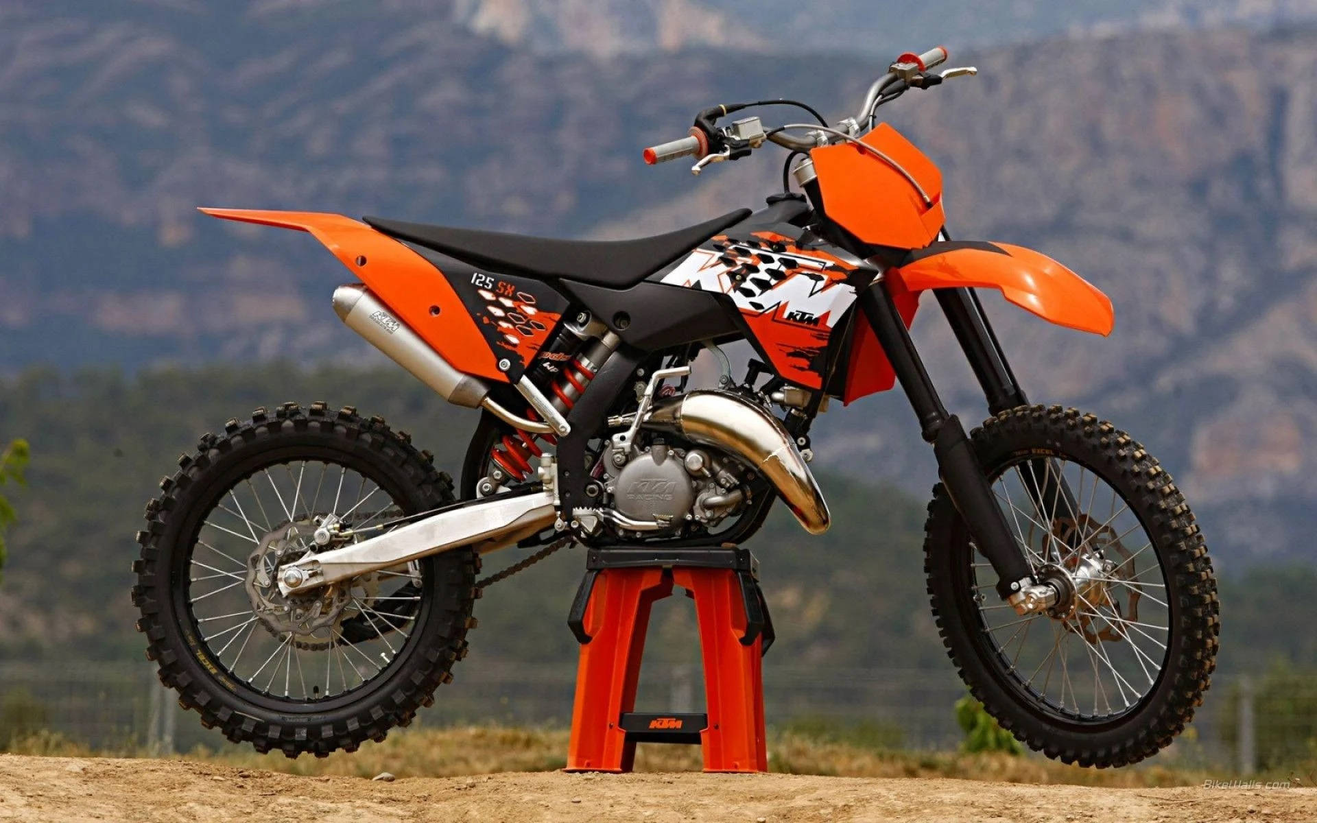 A Dirt Bike Is Sitting On A Stand In The Middle Of A Field Background