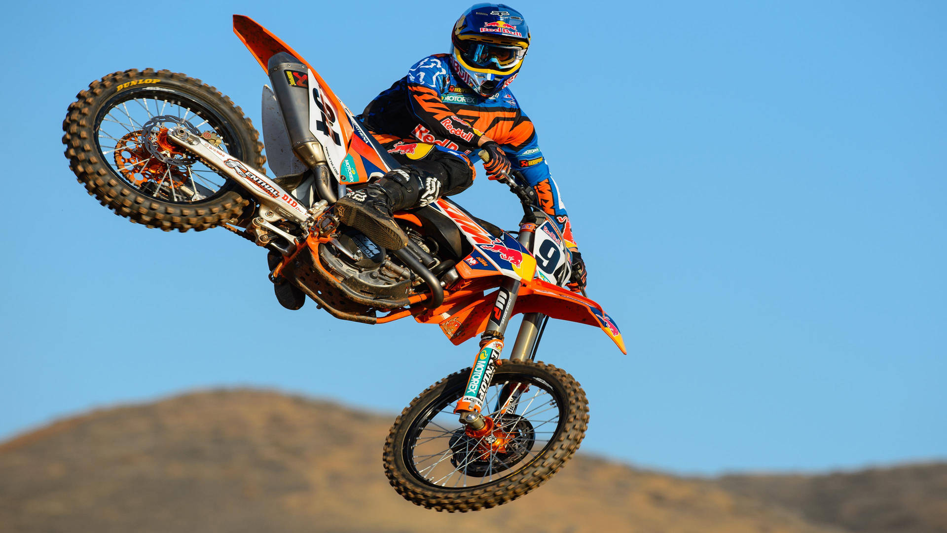 A Dirt Bike Rider In Mid Air Background