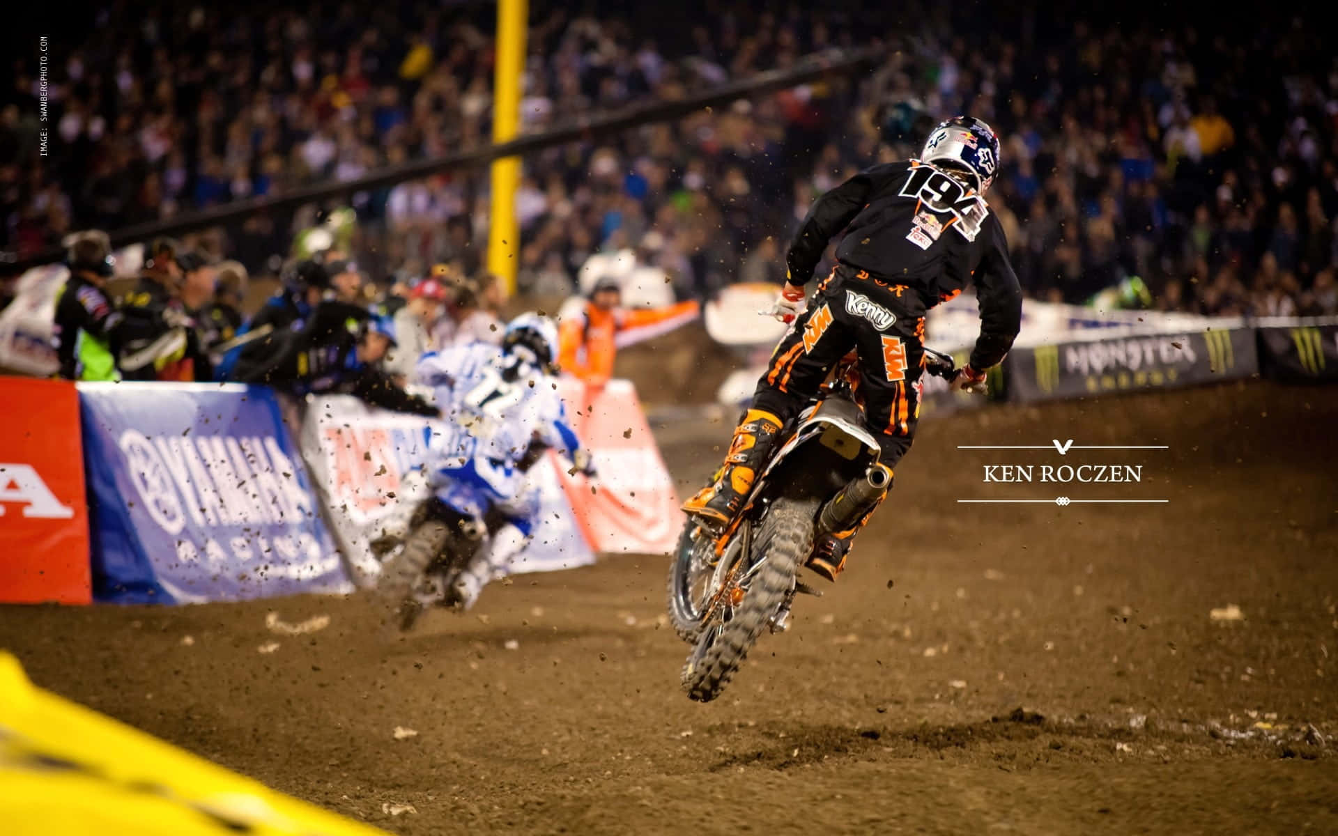 A Dirt Bike Rider Is In The Air During A Race