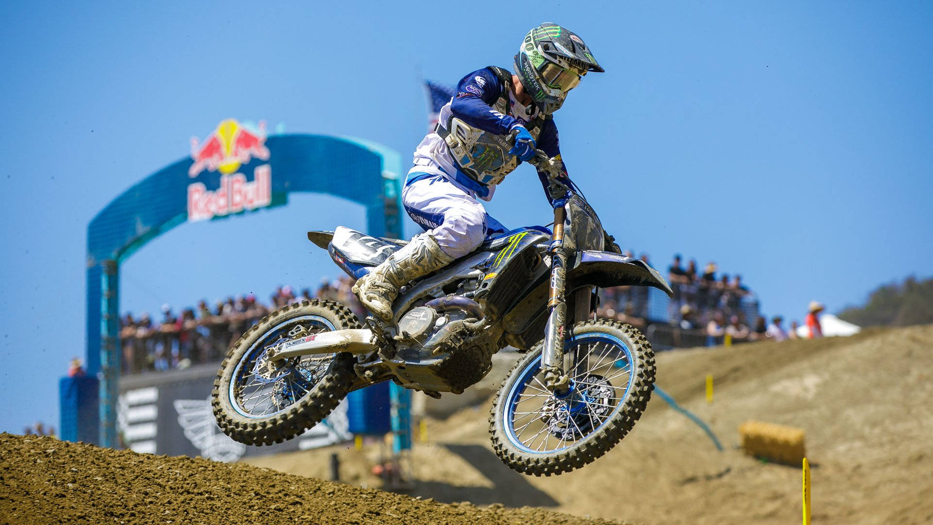 A Dirt Bike Rider Is Riding His Bike On A Dirt Track Background