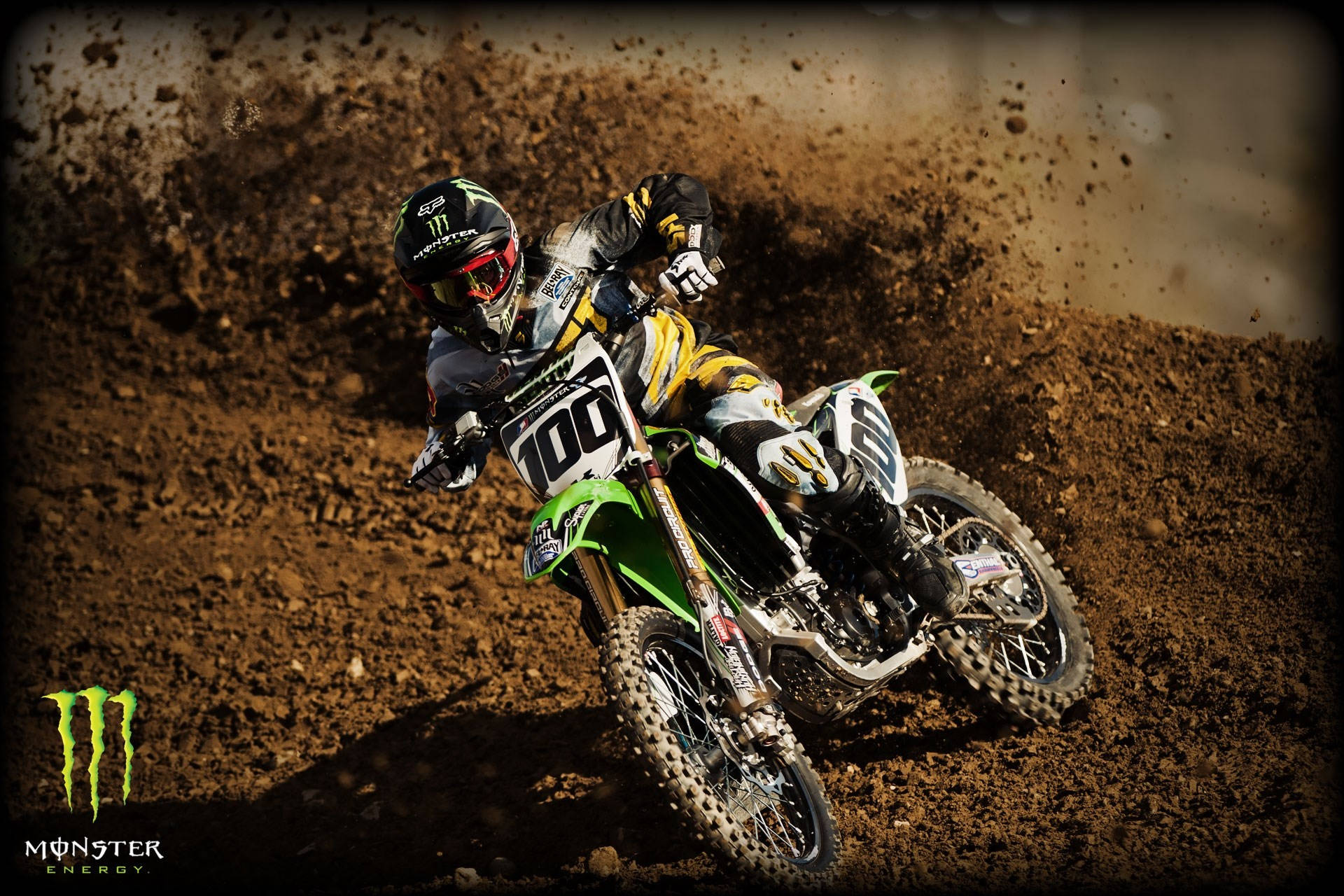 A Dirt Bike Rider Is Riding On A Dirt Track Background