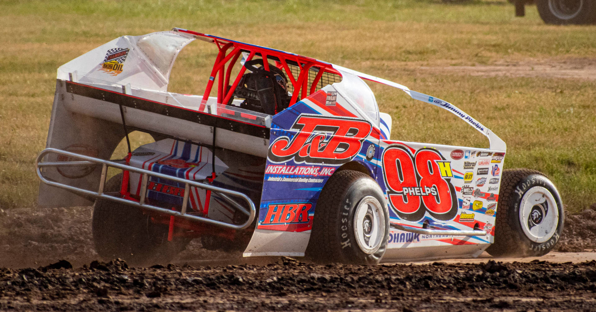 A Dirt Car Driving On A Dirt Track Background