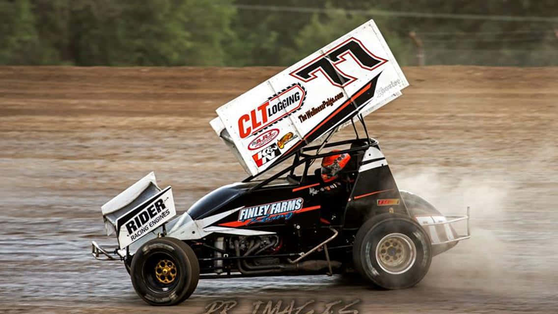 A Dirt Track Race Car Driving Through A Muddy Field Background