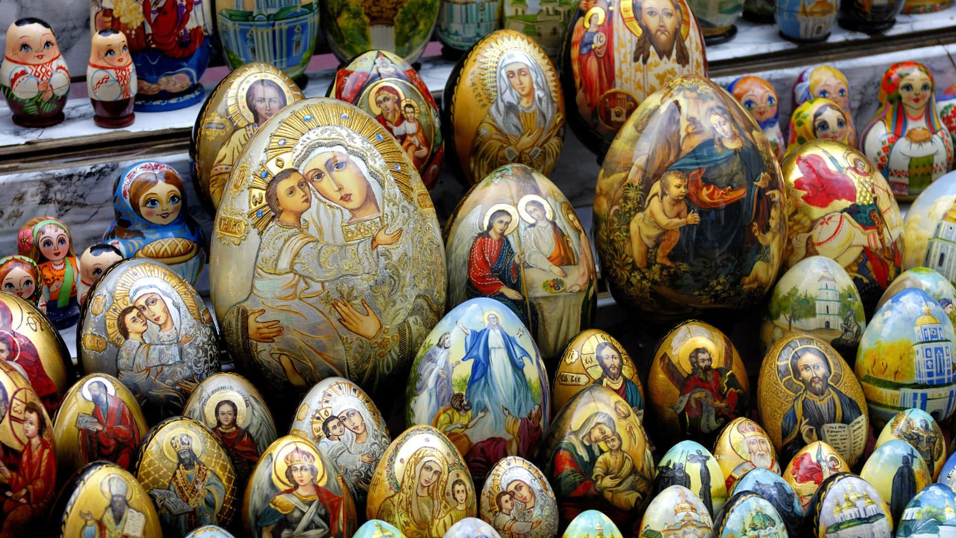 A Display Of Painted Eggs With Religious Images Background