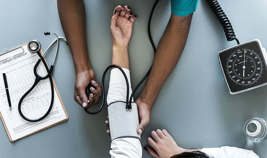 A Doctor Is Taking A Patient's Blood Pressure Background