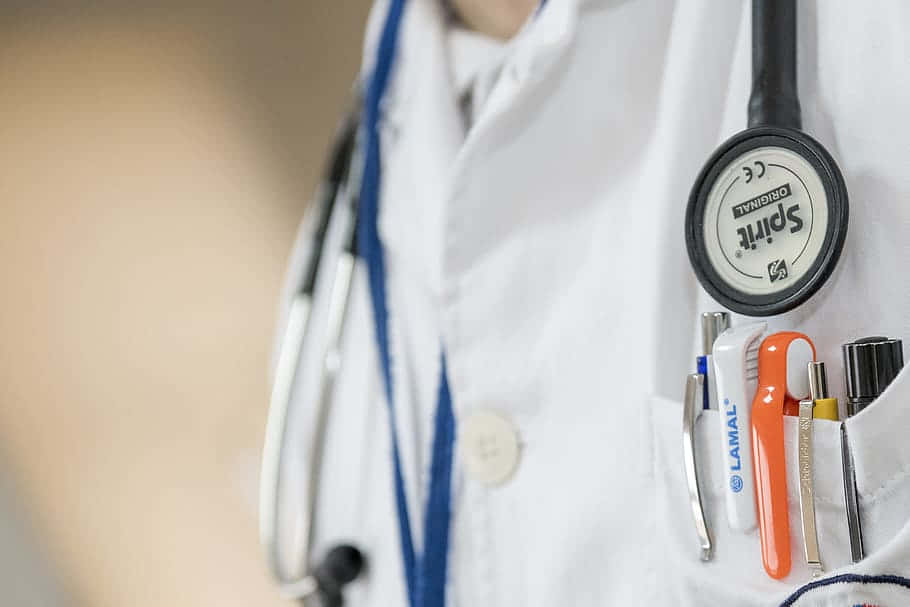 A Doctor's Coat With A Stethoscope And A Pen Background