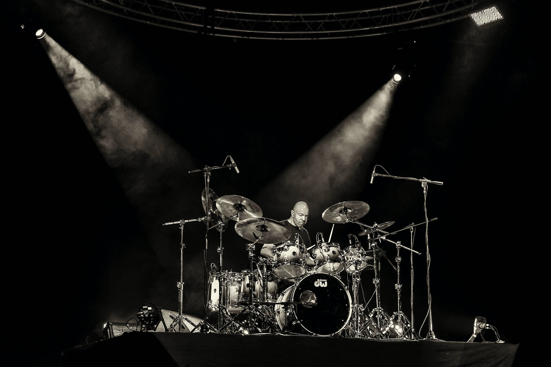 A Drummer On Stage With Spotlights Background