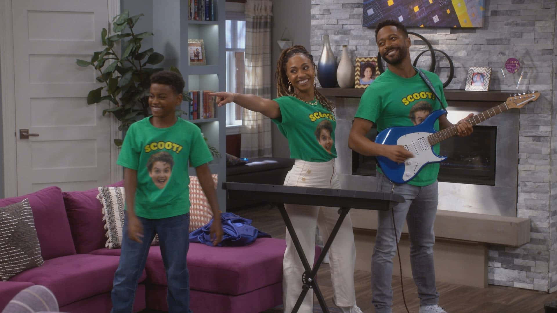 A Family In A Living Room With A Guitar And T - Shirts Background