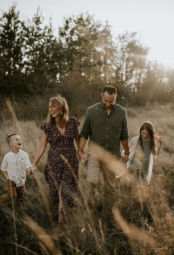 A Family Of Five Smiles Together On A Perfect Day. Background