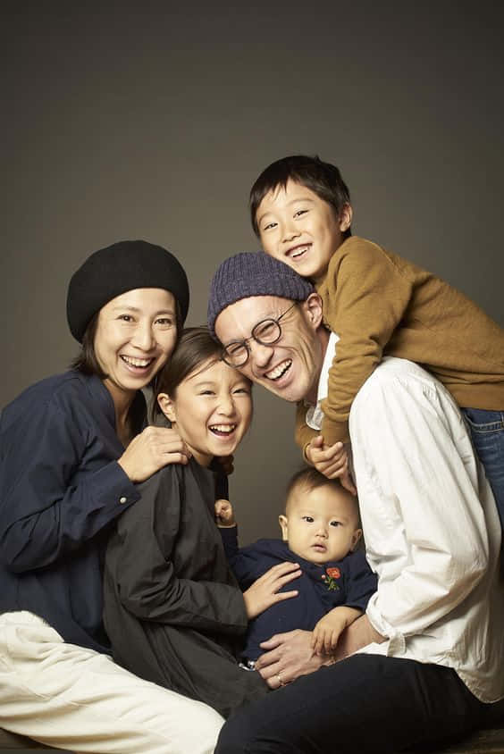 A Family Posing For A Photo Background
